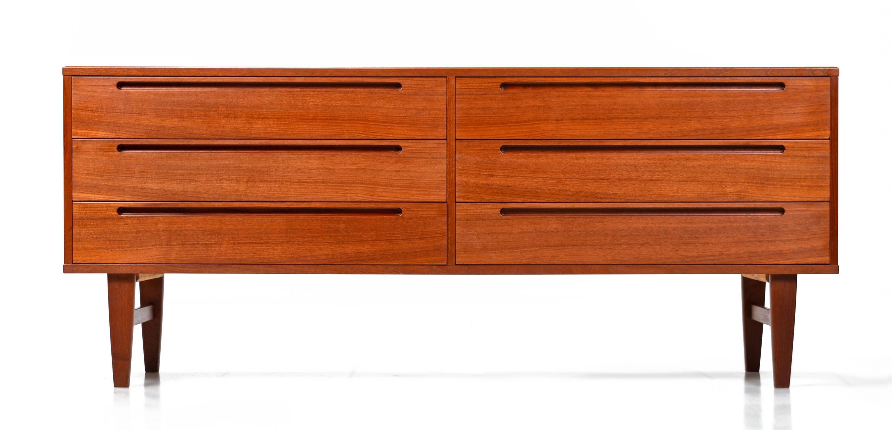 Expertly crafted Mid-Century Modern Danish teak dresser by Nils Jonsson for HJN Mobler. This pieces is an exemplary specimen of Danish cabinet making. Tightly dovetailed drawers, no particle board, beautiful teak wood and easy gliding drawers are
