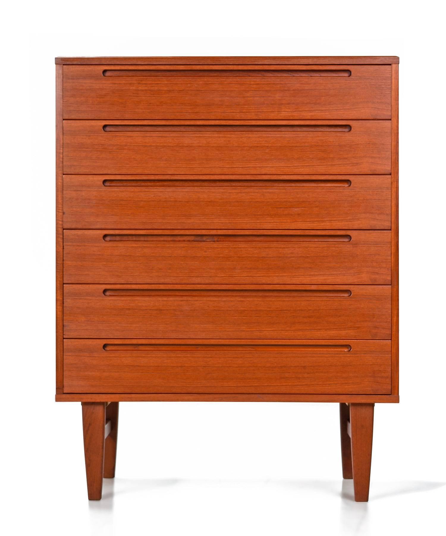 Expertly crafted Mid-Century Modern Danish high boy teak dresser by Nils Jönsson for HJN Møbler. This pieces is an exemplary specimen of Danish cabinet making. Tightly dovetailed drawers, no particle board, beautiful teak wood and easy gliding