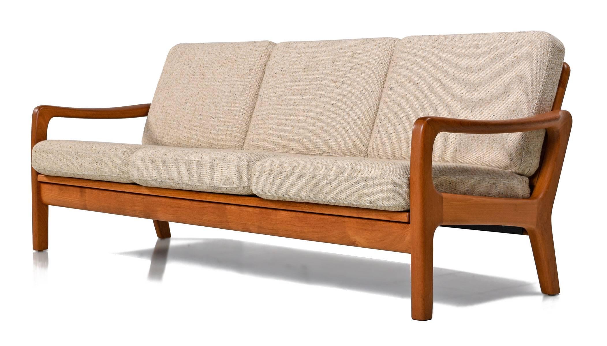The sculpted arms stand out within the sleek, Minimalist, modern, low profile design. Solid teak frame with rigid construction. Cushions, fabric and springs are in near mint condition. Sofa folds down flat to become a daybed. Two hinged legs can