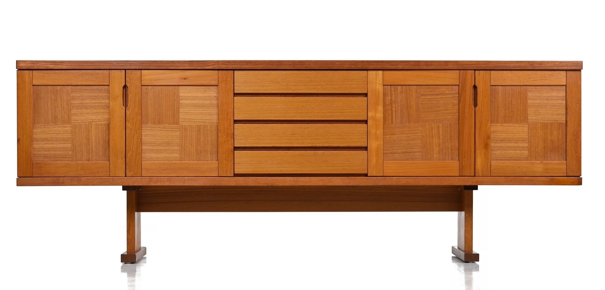 This long Danish teak credenza would be perfect in a living room as an entertainment console or in the dining room as a traditional buffet. The autumnal themed tiles complement the parquet wood patterns on the cabinet doors. These unique and