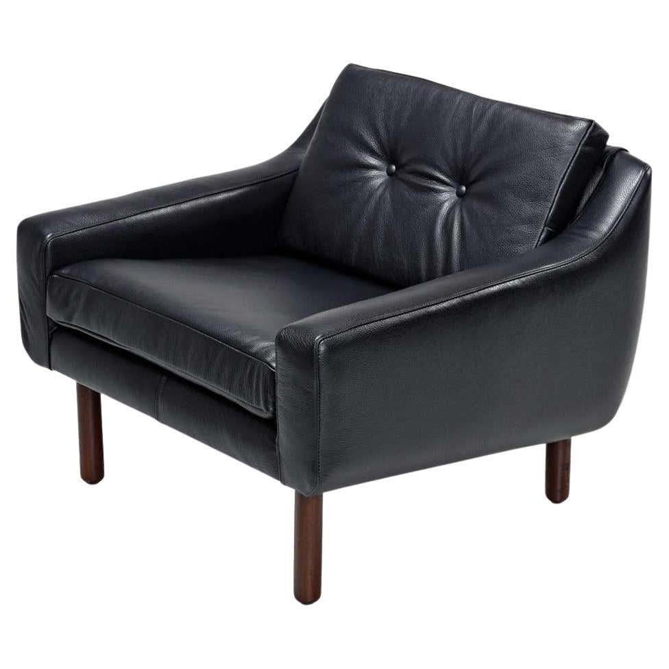Fully restored with new luxurious black leather. This Mid-Century Modern lounge chair had no marking, but it's clearly in the style of Frits Henningsen and Svend Skipper, made in the 1960s. This low-back armchair features a sleek profile in the