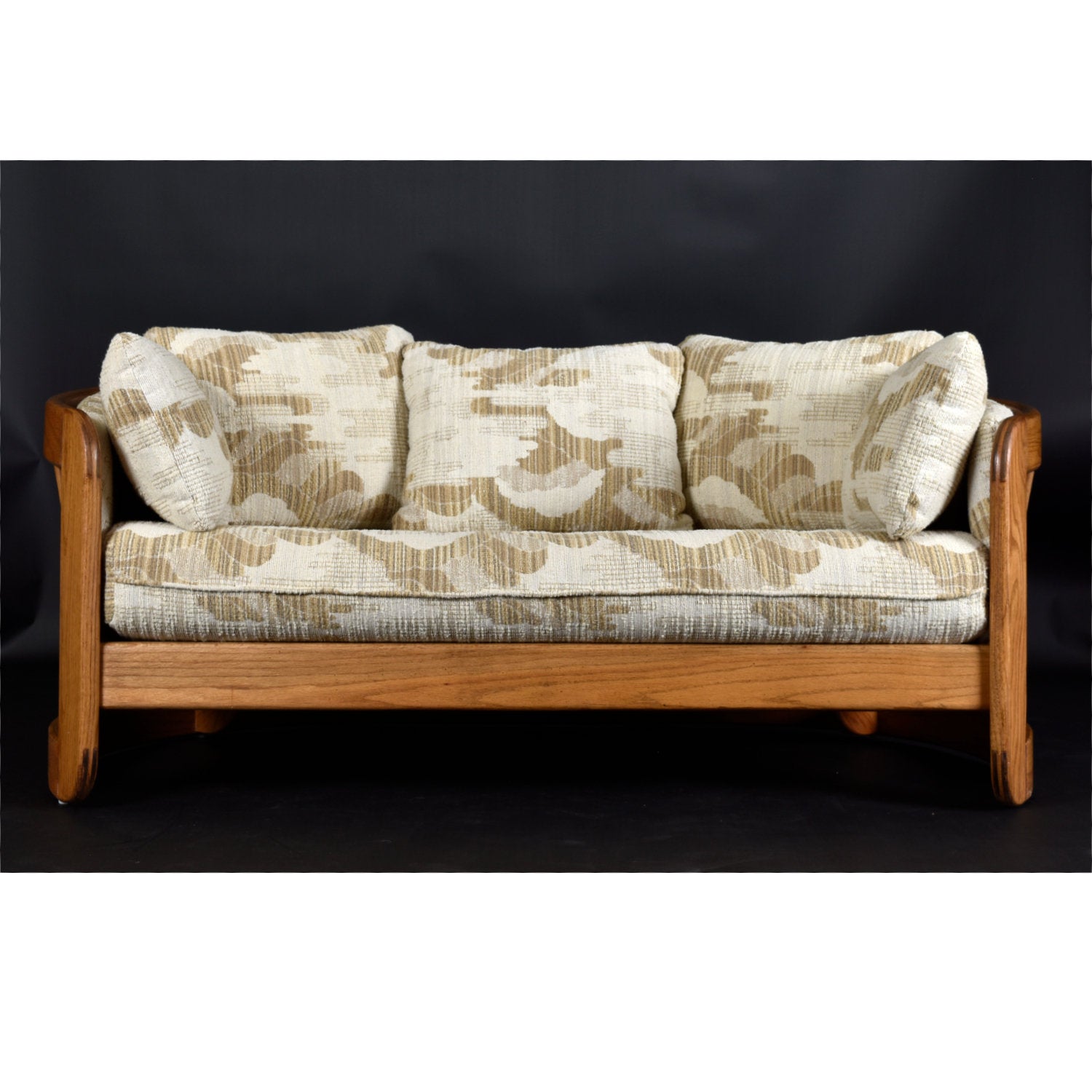 Comfort is king with this stylish vintage 1980s barrel shaped loveseat sofa by Howard Furniture. American made, solid oak throughout! The ultra cozy loveseat is wide and padded with plush pillows. The semi-circular surrounds the body, as if it’s