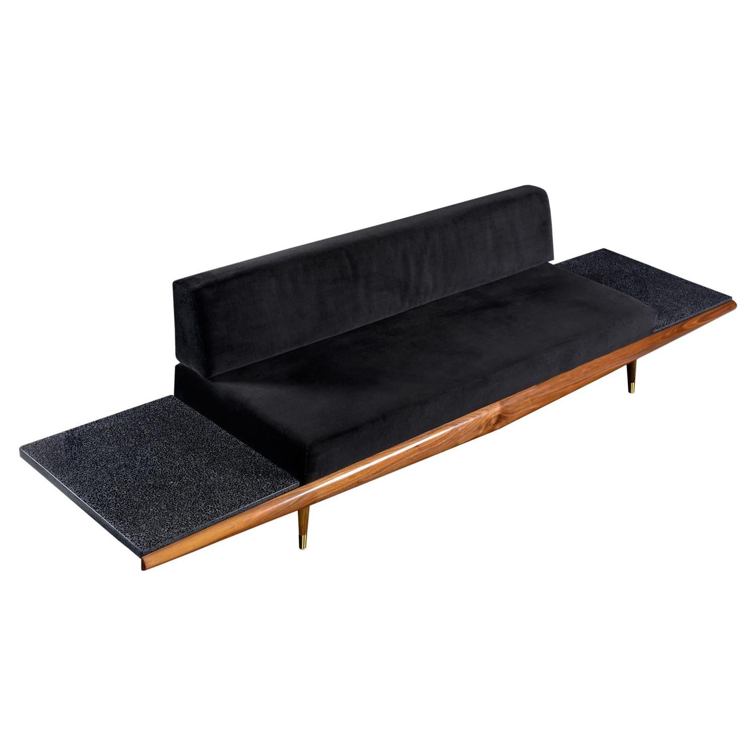 Dramatic, beautiful and sinister. At well over 10 feet long, this Adrian Pearsall sofa appears to be soaring like a B-2 bomber with the built-in, floating black terrazzo end tables extending like wings off the frame. Recently upholstered in black