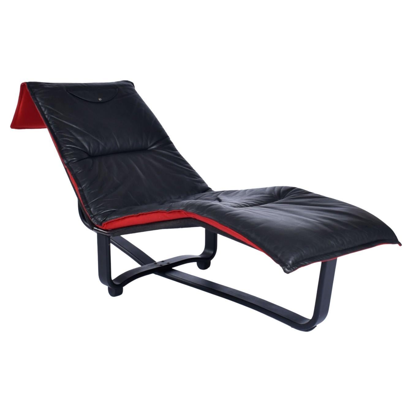 Westnofa Norwegian made leather chaise lounge with reversible cushion. This chaise is exemplary of Scandinavian design genius. It achieves so much, by such simple means. The original cushion is black leather on one side, and red wool on the other