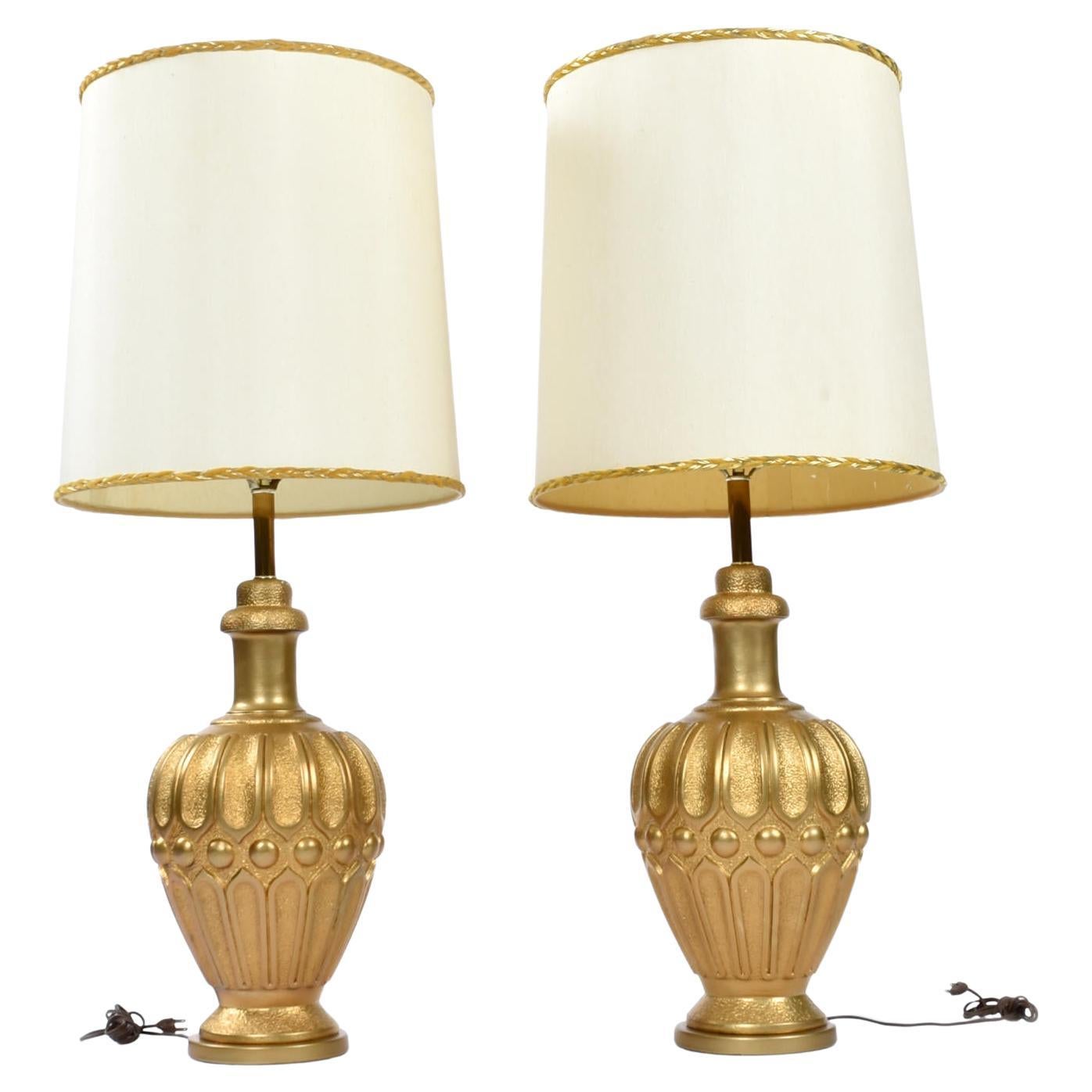 The shades pictured are NOT included with purchase. 

Pair of large Mid-Century Modern gold colored Chalkware genie lamps. The lamps have a regal Mediterranean or even Middle Eastern feel. The lamps are shaped like urns with textured channeled