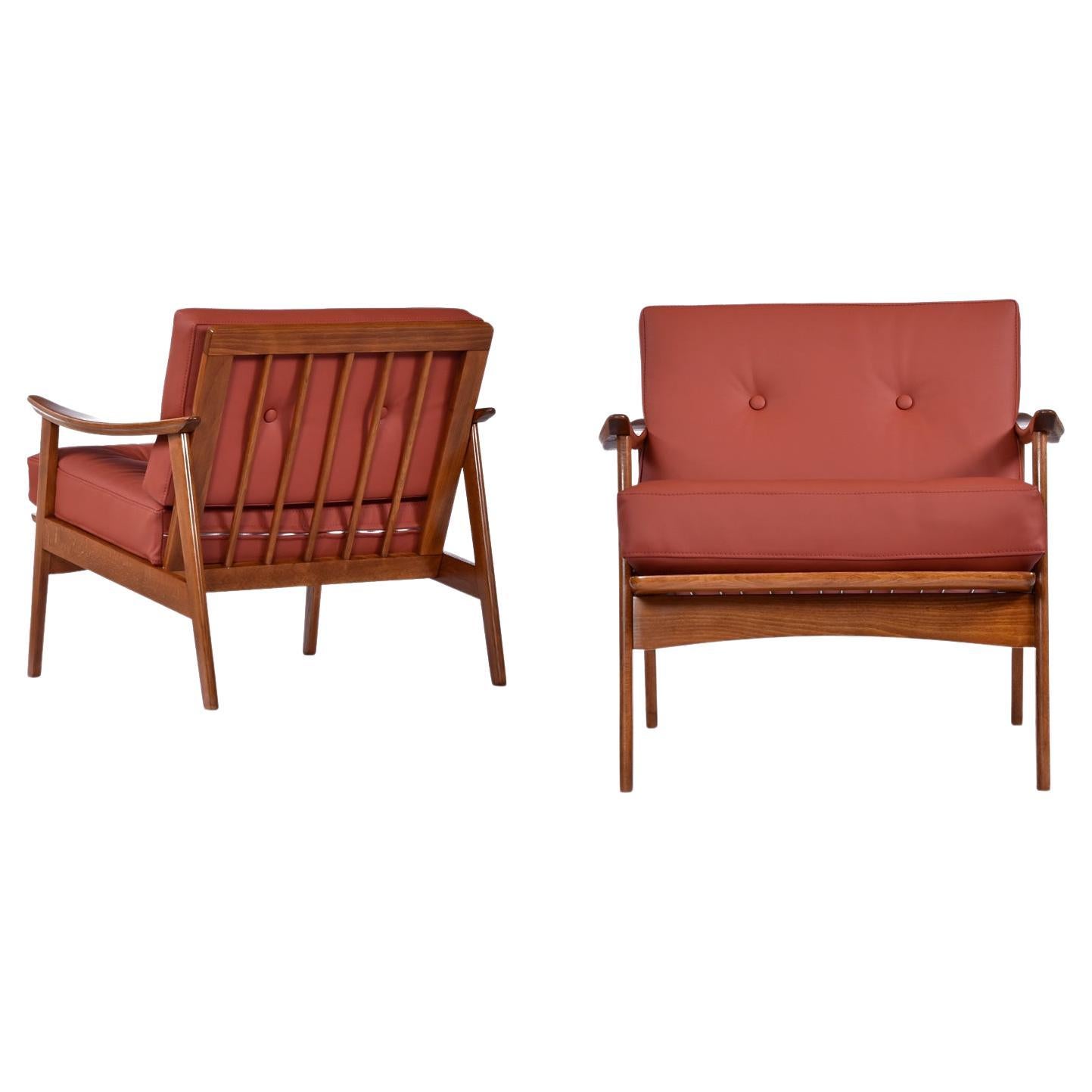Handsome pair of solid beech wood Mid-Century Modern armchairs made in Scandinavia. These classic, timeless armchairs have been refinished and updated with all new top grain burgundy-cognac leather upholstery and handsome button tufting.  Tailored
