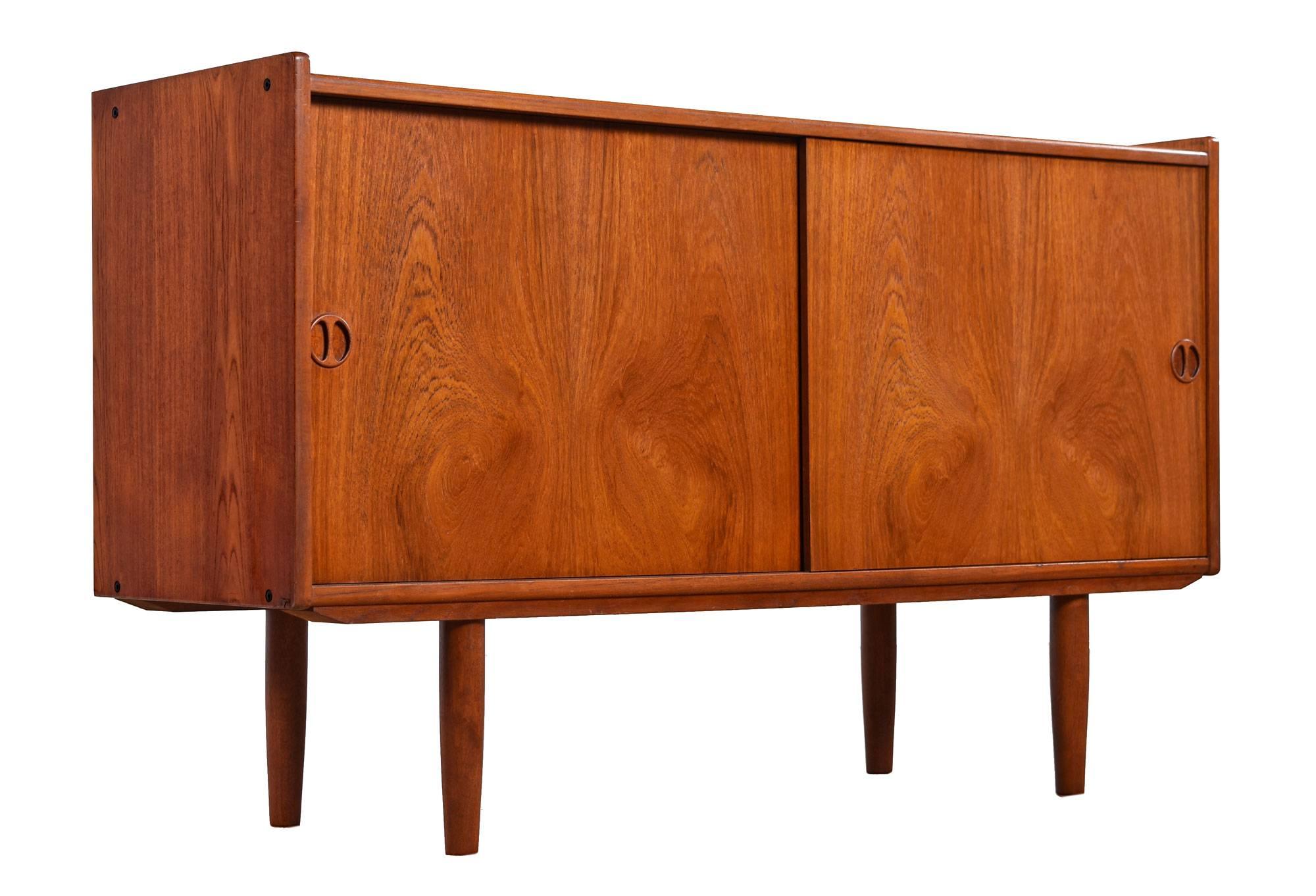 Handsome restored Mid-Century Modern, Danish teak credenza by Jydsk Mobelindusti of Skanderborg, Denmark. The unit still bears the maker's mark on the back side. This early piece has deep red/orange patina to the half-a-century old teak wood. Ideal