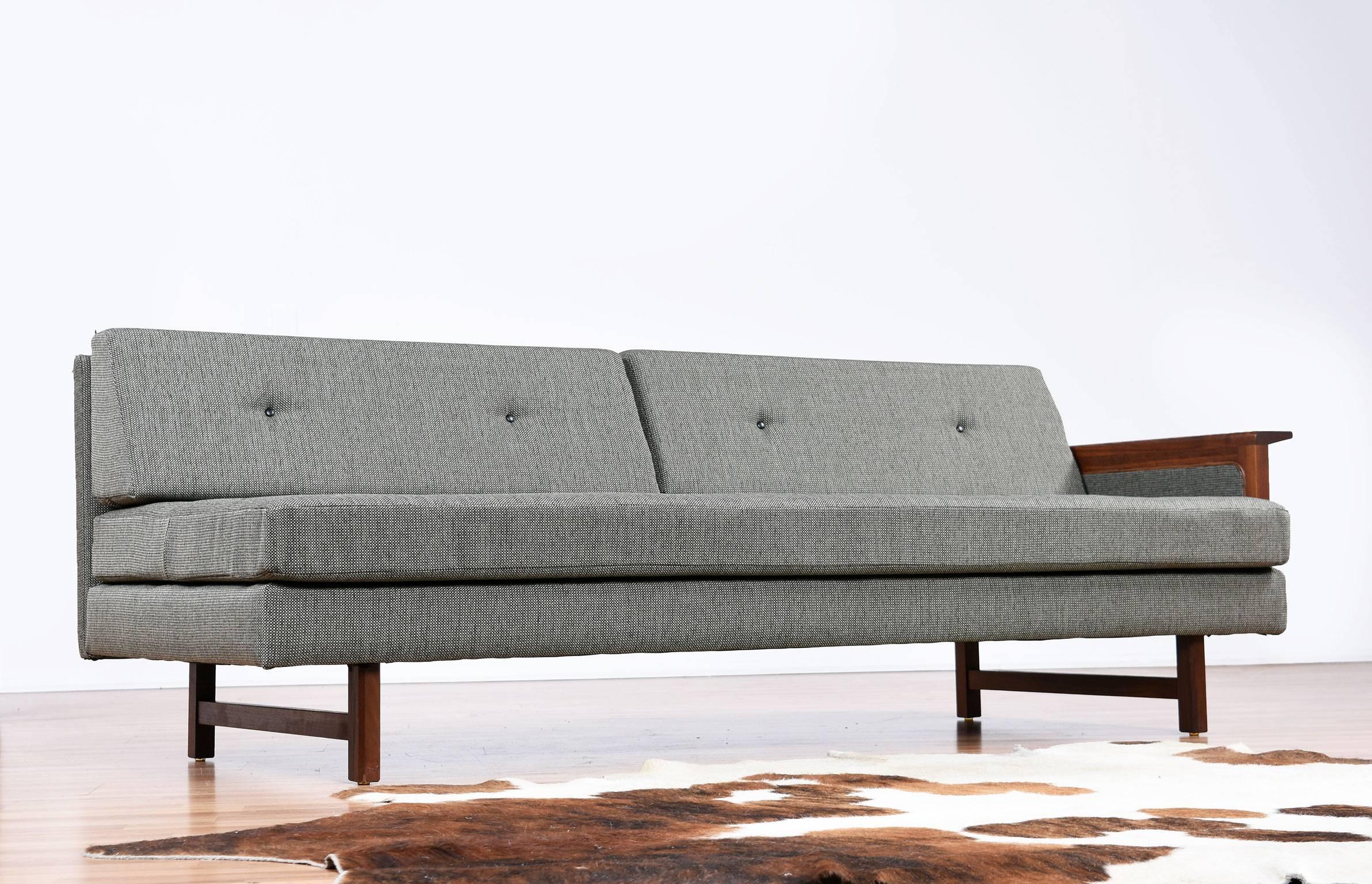 Restored Mid-Century Modern one armed sofa. This sofa has got the full treatment with new cushions, fabric and refinished walnut wood. It’s practically like having a brand new vintage sofa. The fabric is a blend of olive green, beige and black and
