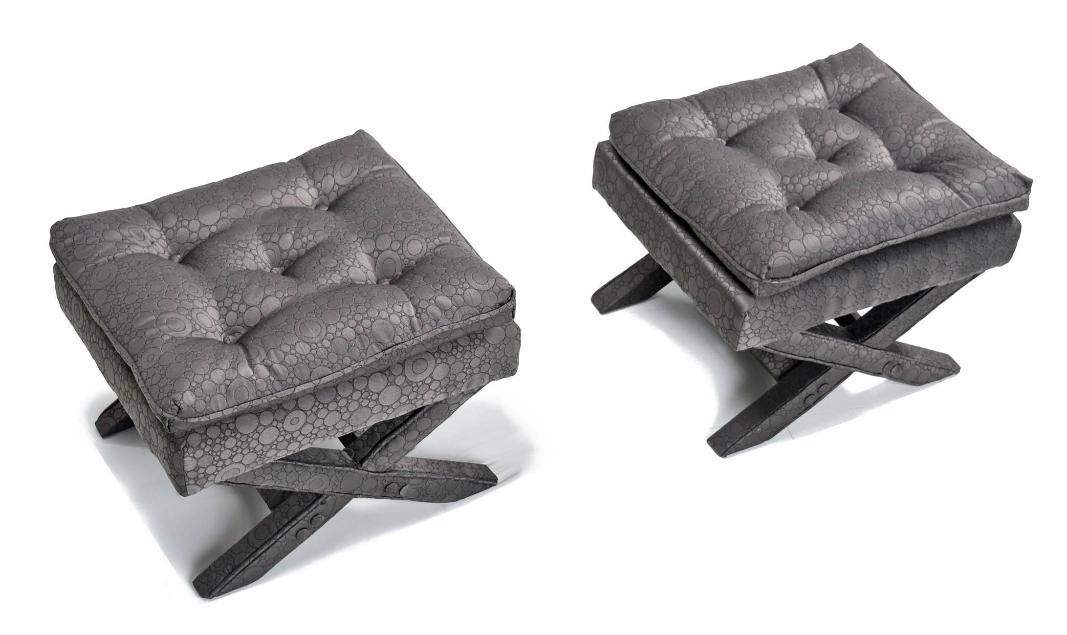 A pair of Billy Baldwin benches or ottomans professionally newly upholstered in modern grey fabric. Button tufted and elegantly detailed with welting throughout legs. A perfect combination of Hollywood Regency and Mid-Century Modern design.