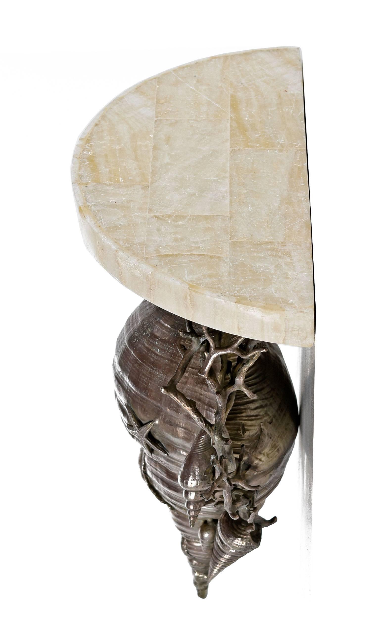Massive sconce (non-lighted) shelf by Maitland Smith. This decorative conch shell is only one of the many deeply detailed sea scape subjects in this solid, pewter-like metal medium. When mounted to a wall the beveled marble shelf top serves as