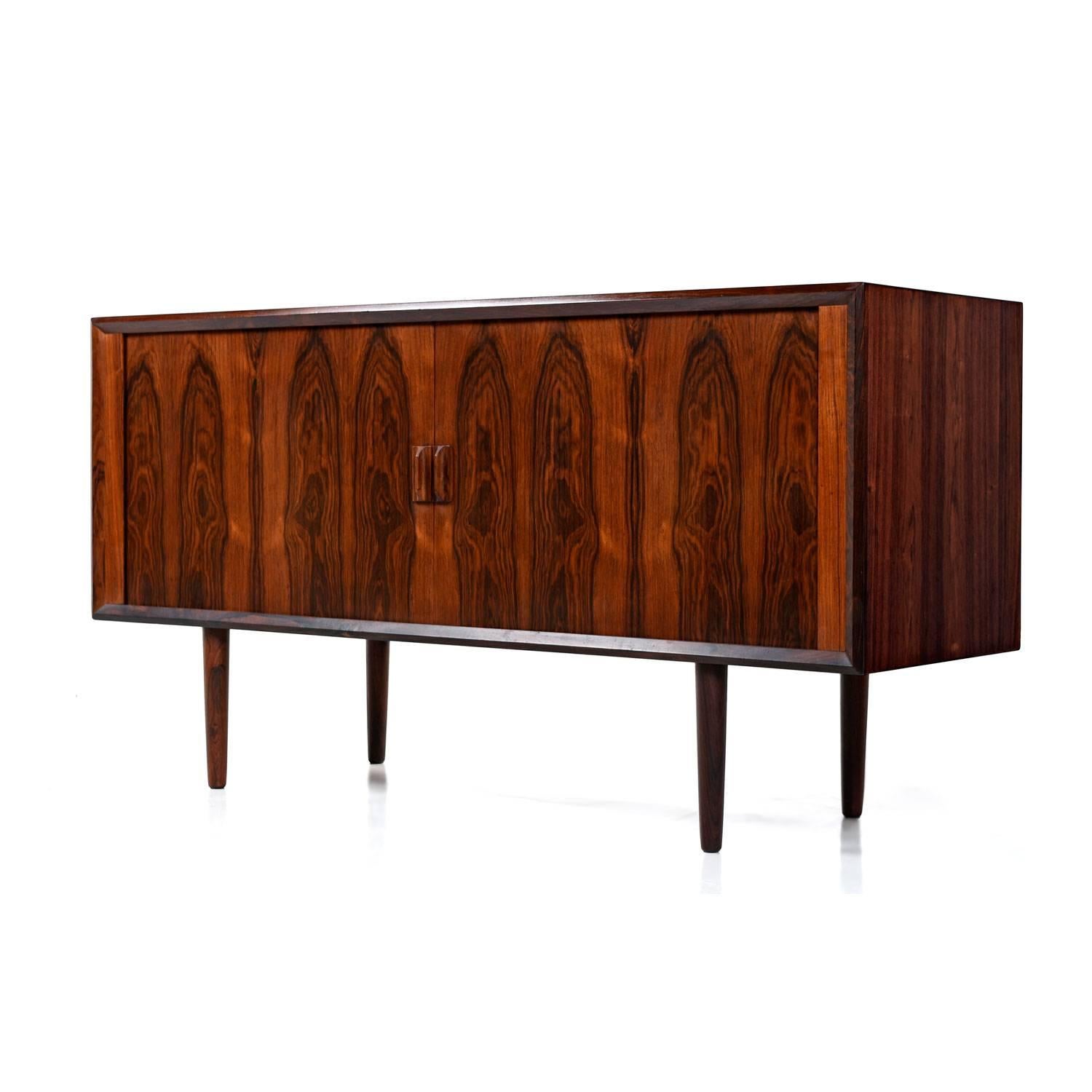 The rich, oxblood colored rosewood is the high water mark of Scandinavian cabinet making. Notice the wild, flaring, cathedral grain. The old growth trees that supplied manufacturers during the mid-century are long gone. Matched grain pattern tambour