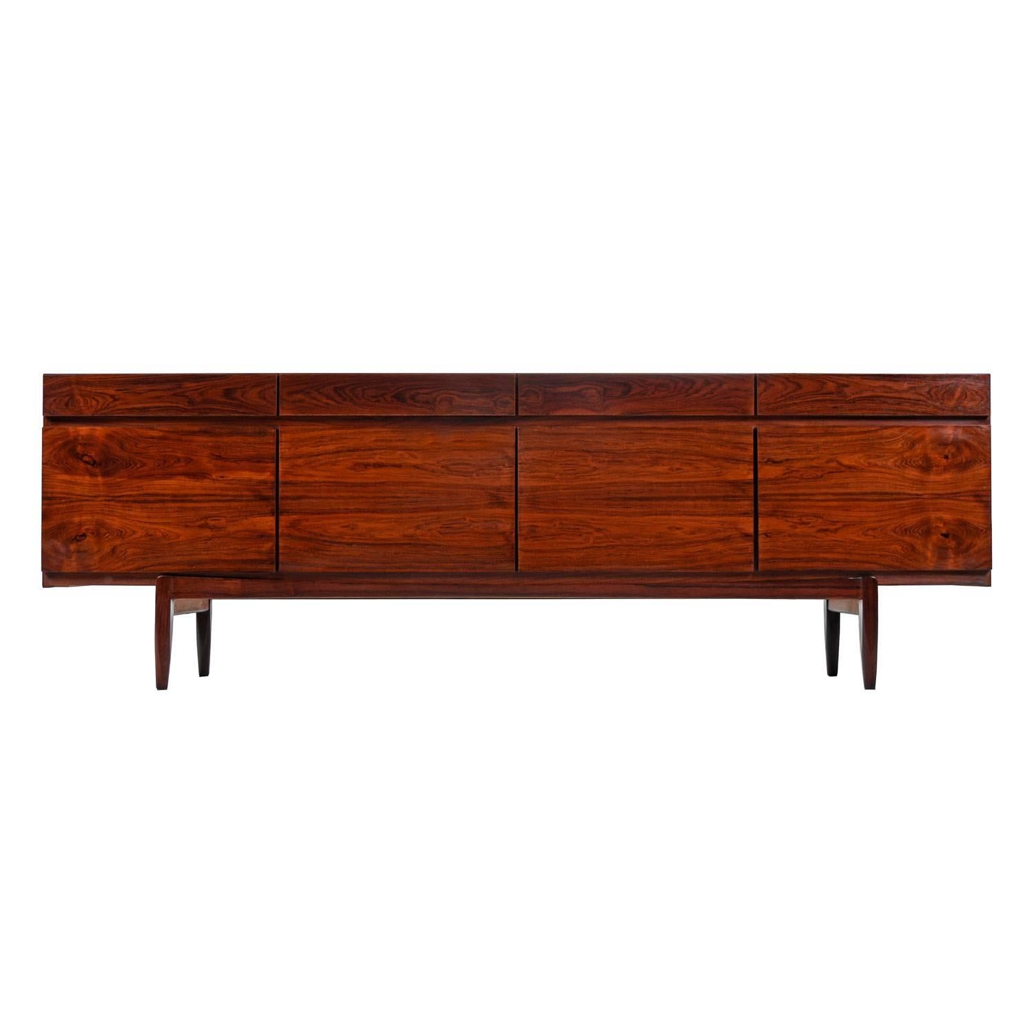 The rich, oxblood colored rosewood is the high water mark of Scandinavian cabinet making. Notice the wild, flaring, cathedral grain. The old growth trees that supplied manufacturers during the midcentury are long gone. Matched grain pattern cabinet