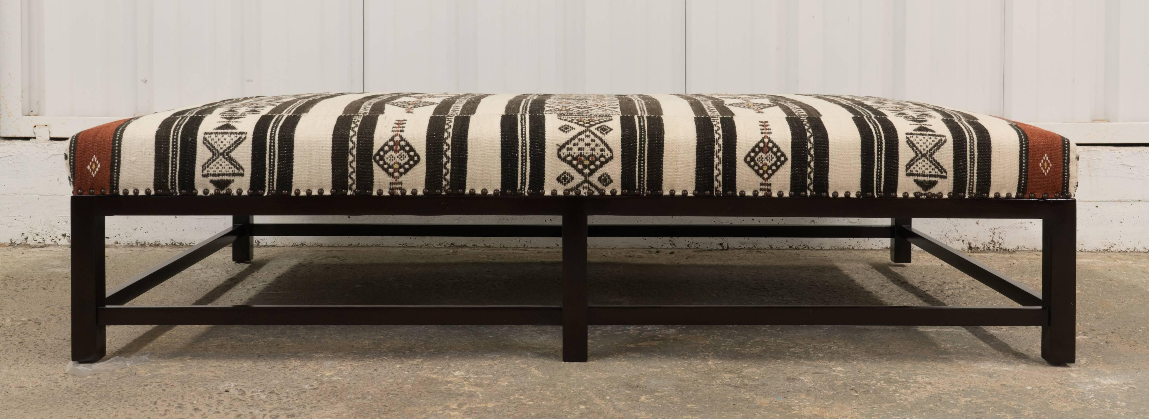 Handmade in Los Angeles, the Hollywood at Home Lexington Ottoman, upholstered in a vintage black and white textile with antiqued bronze nail head trim and a dark walnut finish on wood base.