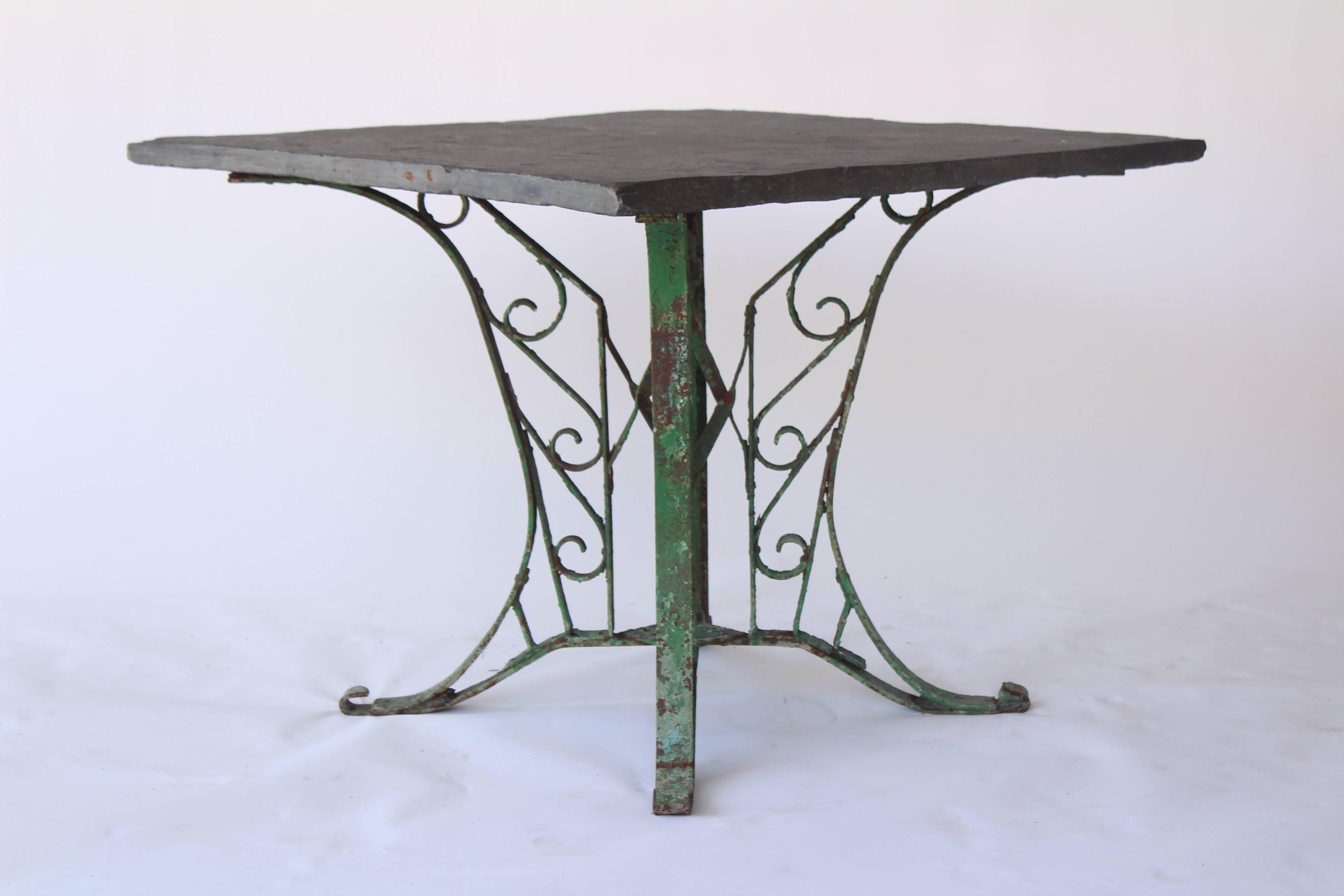 Vintage indoor or outdoor square table with green painted iron base and slate top from France in the 1920s.
        