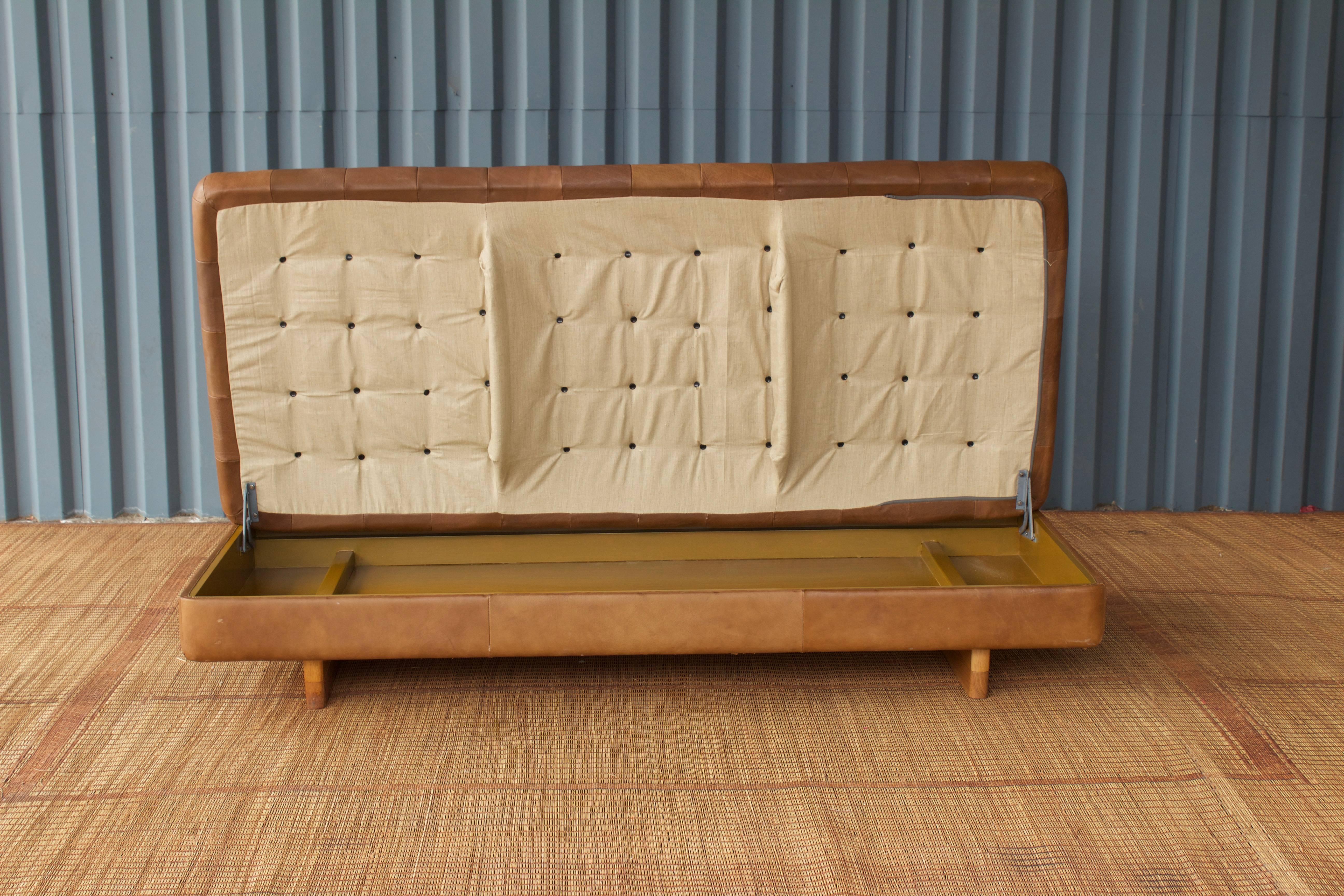 CHIC De Sede biscuit tufted storage ottoman with a handsome low profile. Easy lifting to access storage with stained wood interior. Special piece! Original, broken in leather.