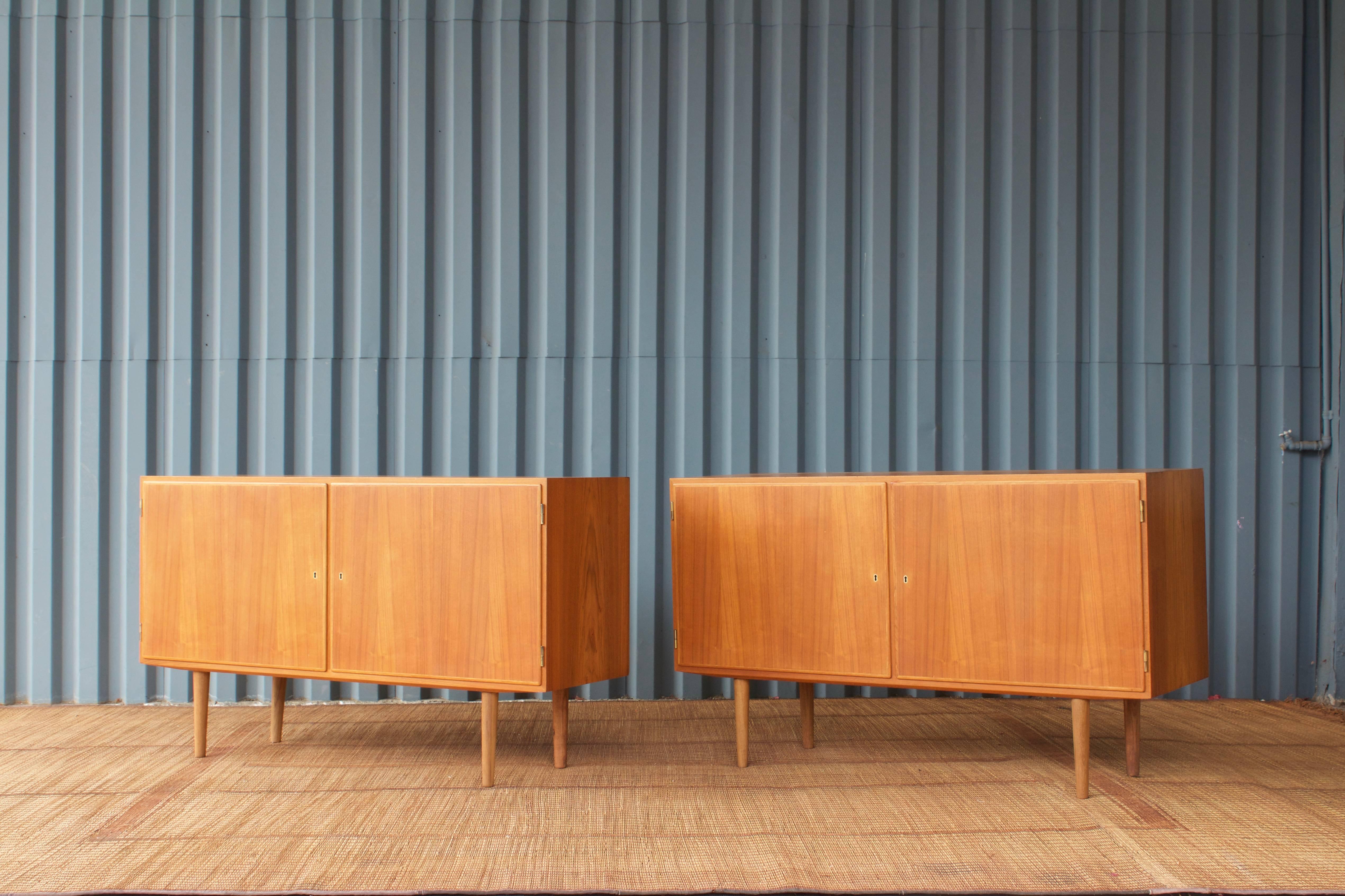 Great, mid-scale credenzas or cabinets from Denmark in the 1960s, made from teak wood. The pair has a Classic Mid-Century vibe and identical modular shelving in each piece. One key works for both cabinets.