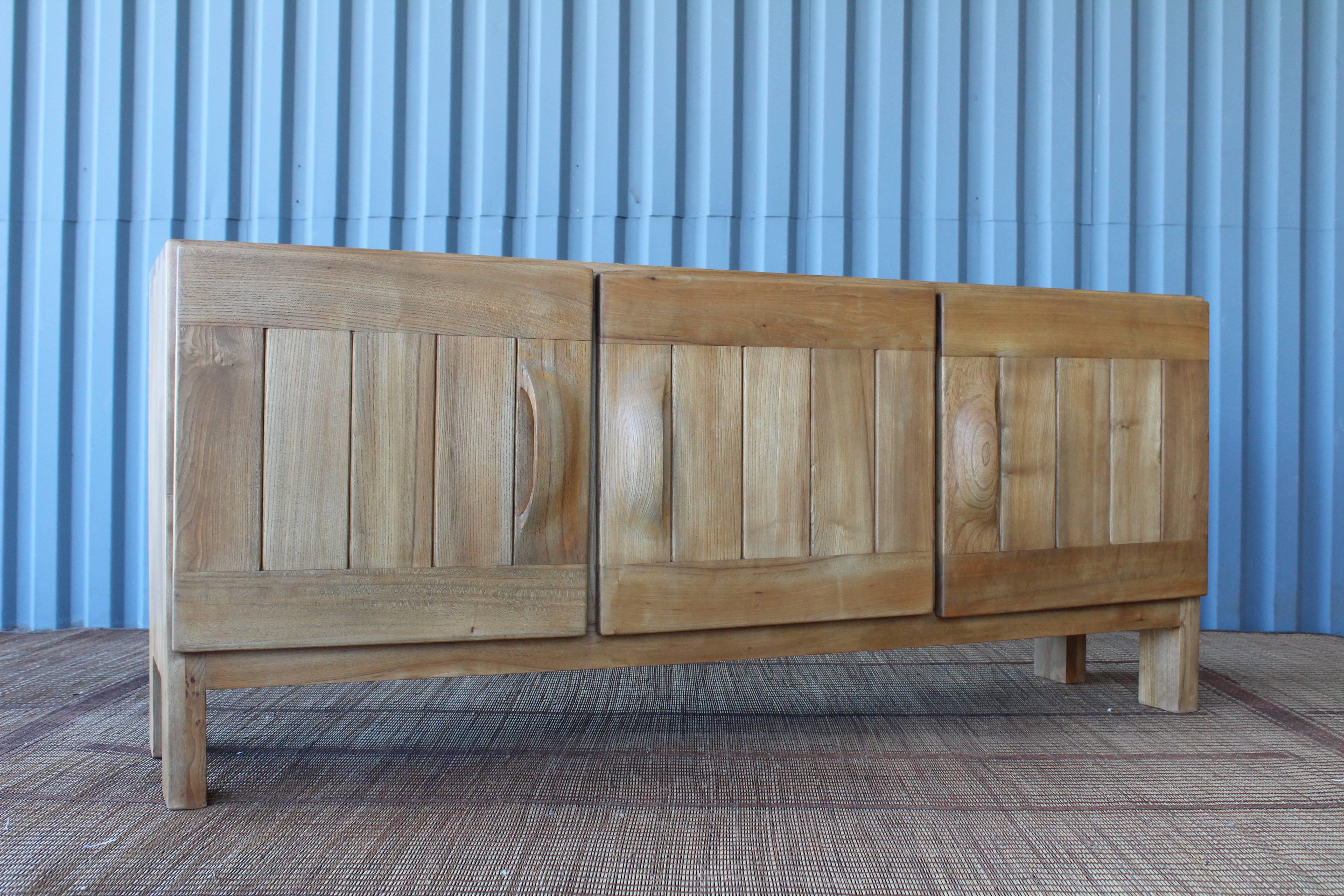 A beautiful 1960s credenza by Maison Regain, France. Finely crafted in solid elm with beautiful visible dovetailed joinery.