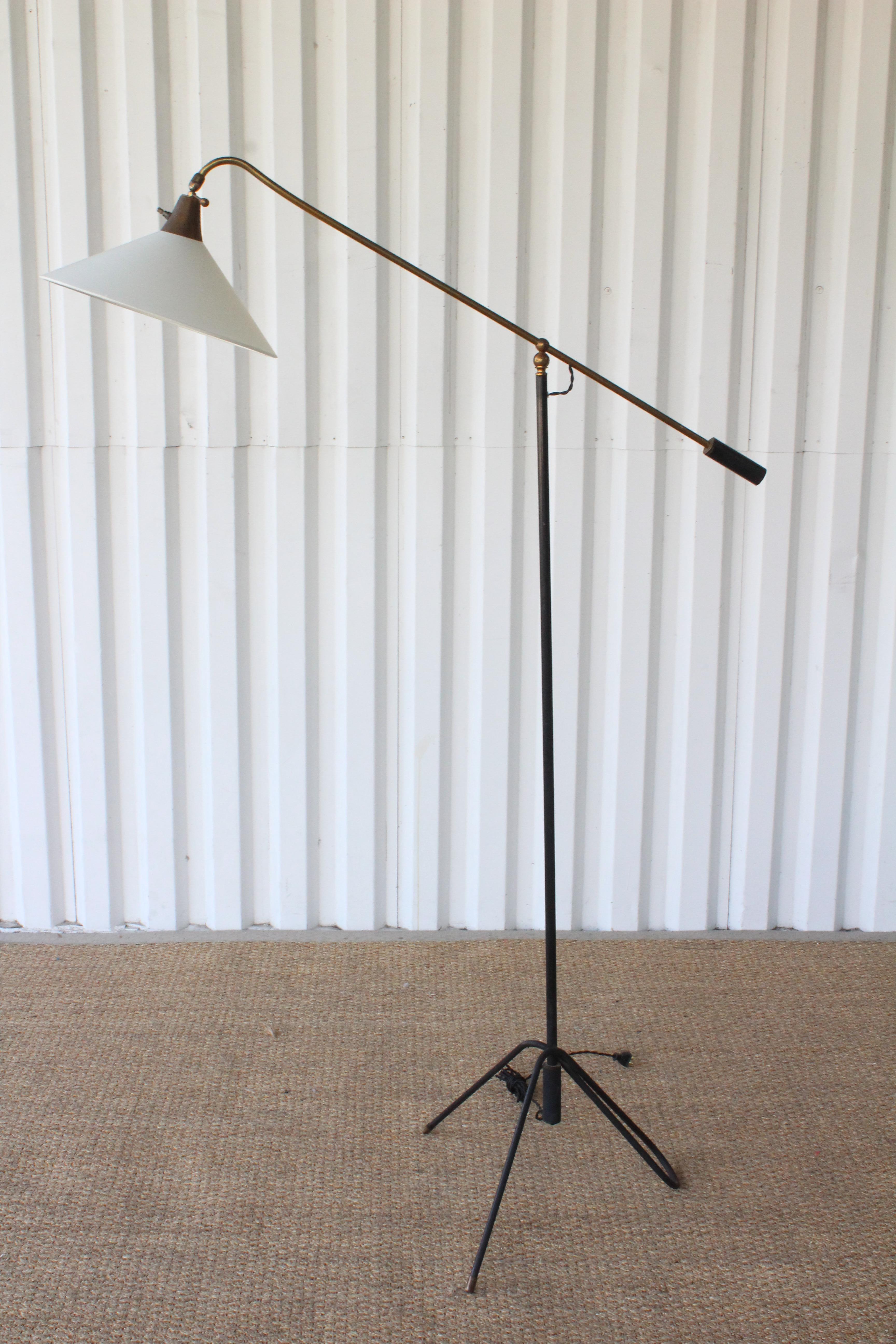 A vintage articulating floor lamp in iron with brass accents. Newly rewired for U.S standards with a new shade in silk. Iron and brass show some patina. The arm is roughly 44