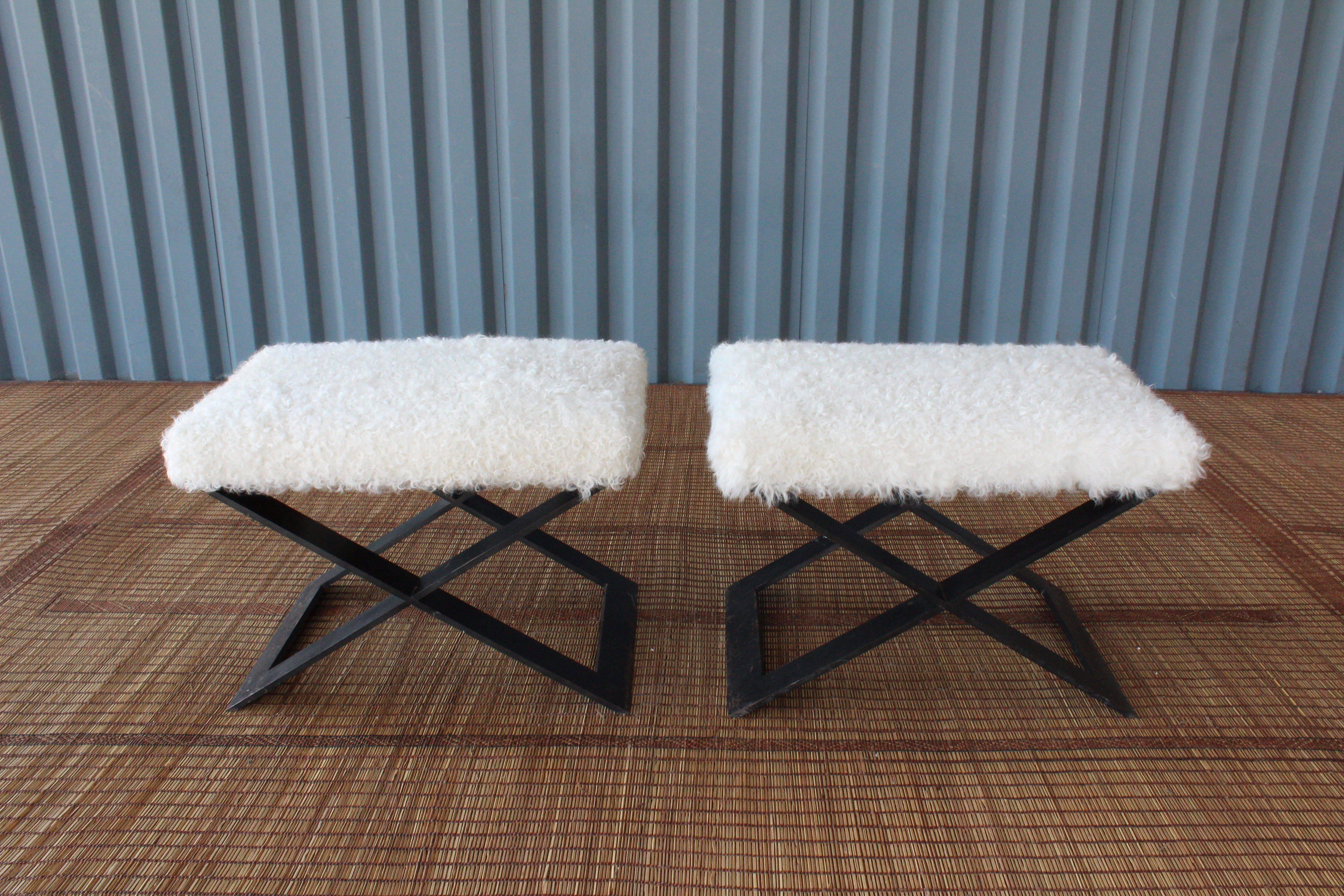 Pair of versatile X-base stools. These stools are made from solid steel and have been newly upholstered in shearling. Bases show age appropriate wear.
