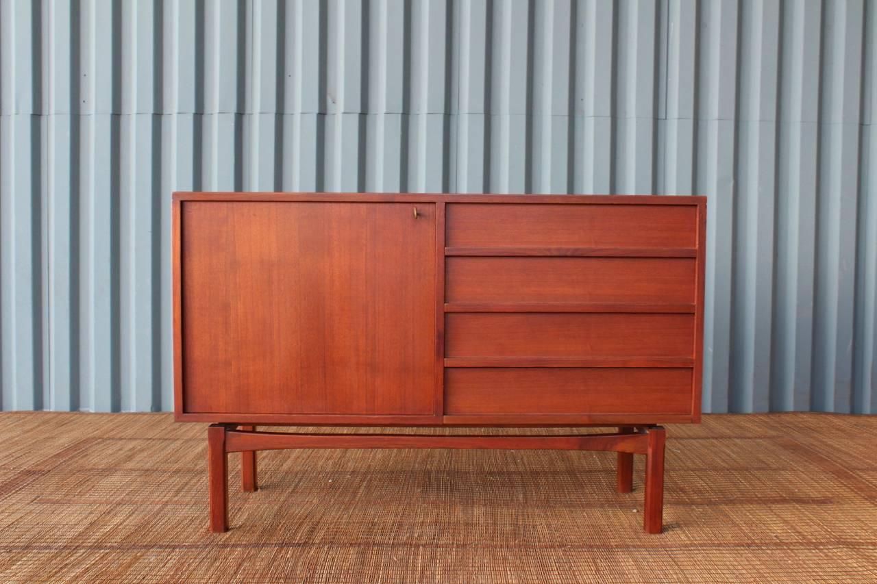 Pair of modestly sized Danish teak cabinets. One offers four dovetailed drawers and a locking hinged door with the original key. The other piece offers two sliding doors with adjustable shelving inside. They look great side by side as a pair. Price