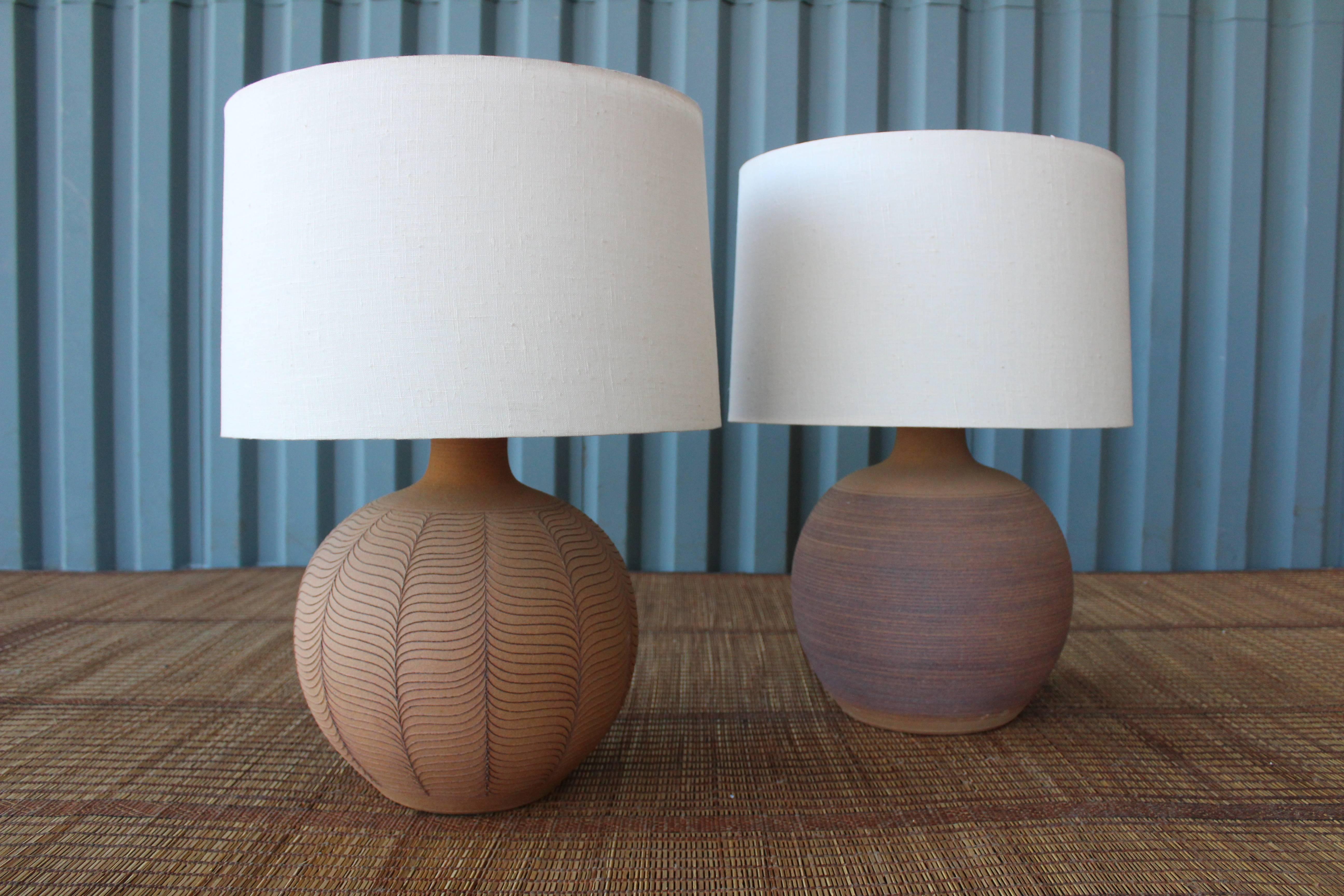 Pair of beautiful hand thrown 1970s terracotta Studio Pottery table lamps. Both signed 'Brown' near the bottom of each lamp. The pair come with custom-made linen shades complete with diffusers.