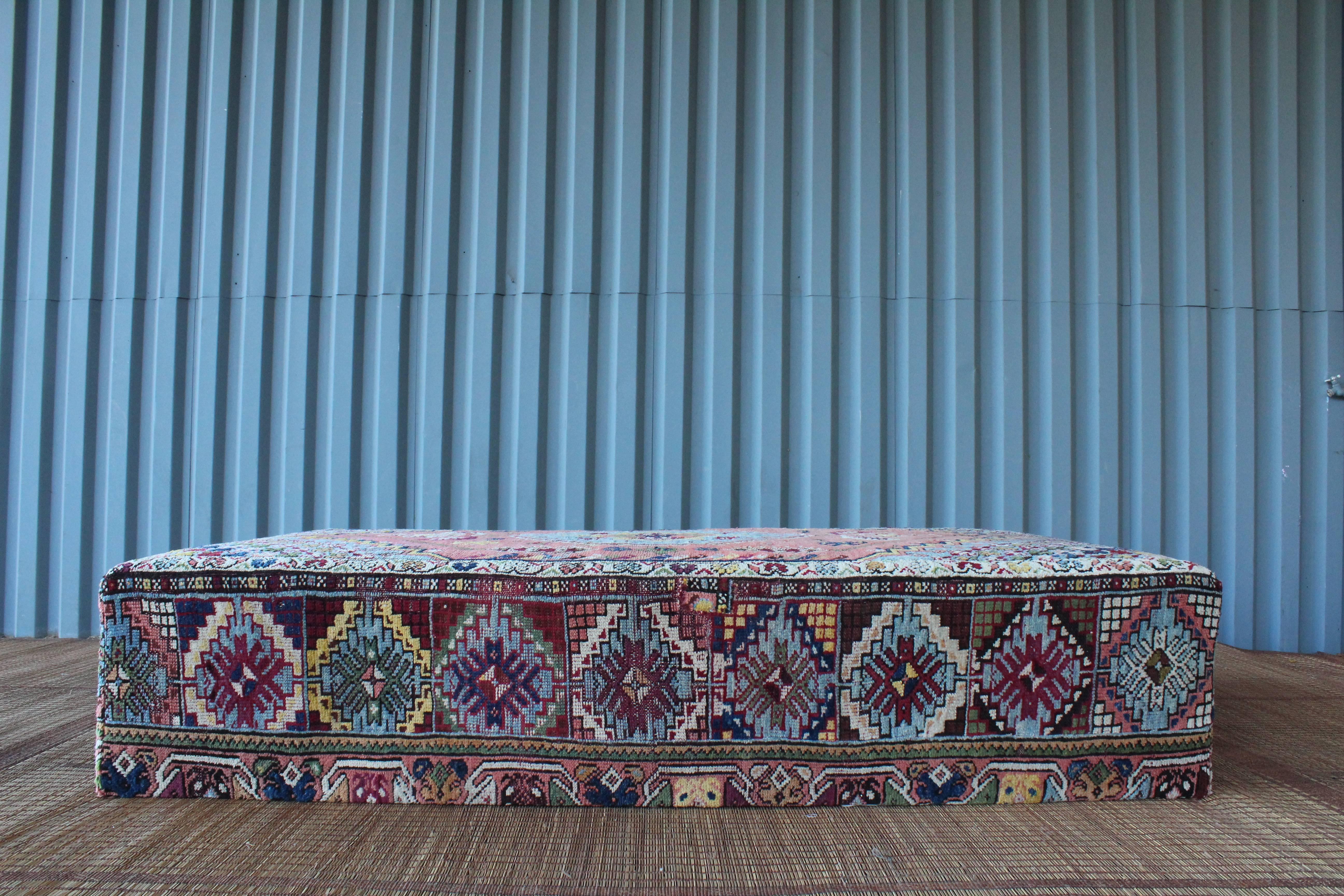 A one-of-a-kind custom-made ottoman or coffee table upholstered in a fabulous vintage Turkish wool rug.