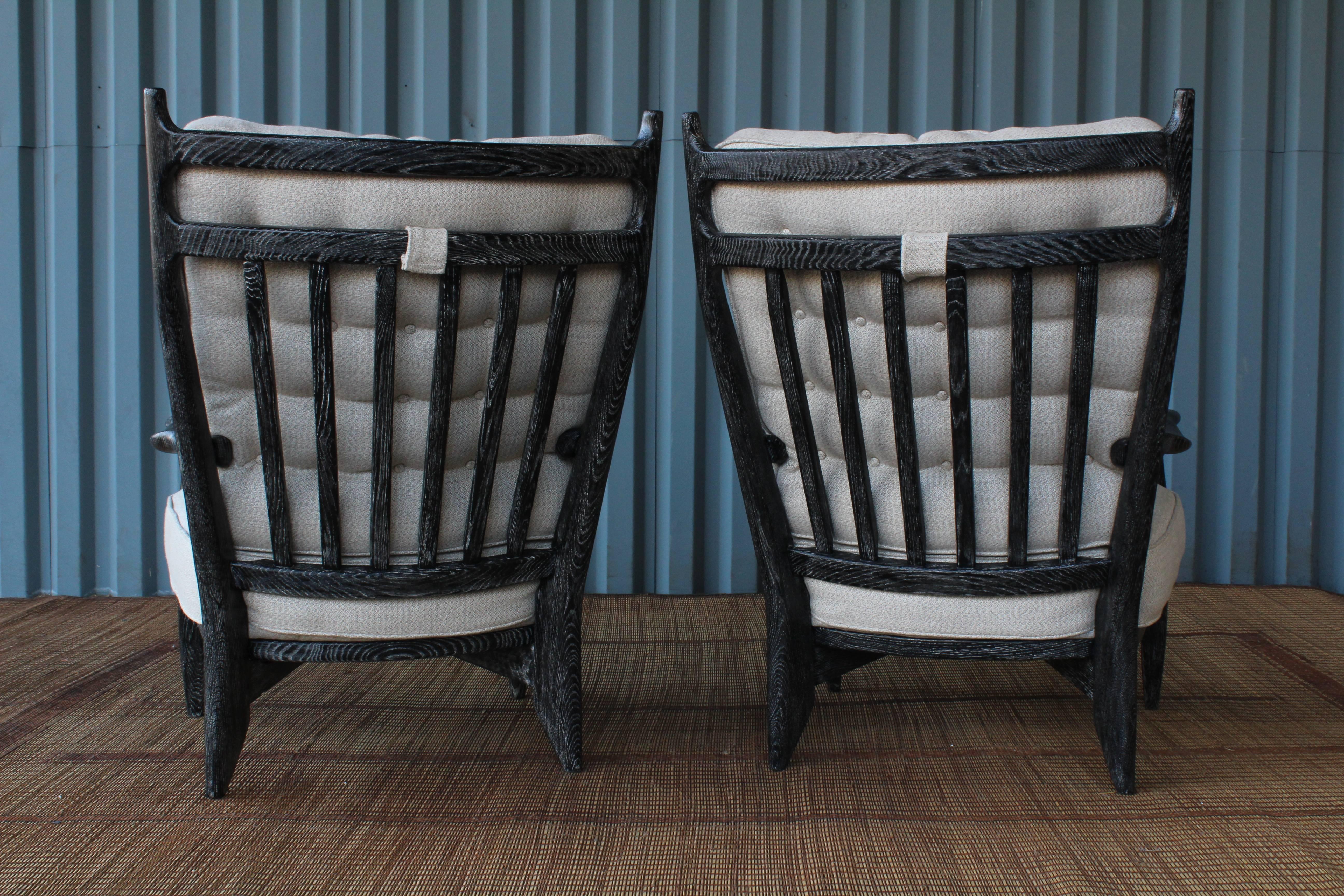 Pair of 'Edouard' armchairs by Guillerme et Chambron for Votre Maison, France, 1960s. The pair have been updated in a black cérused oak finish and have new upholstered cushions in a subtle beige woven fabric.