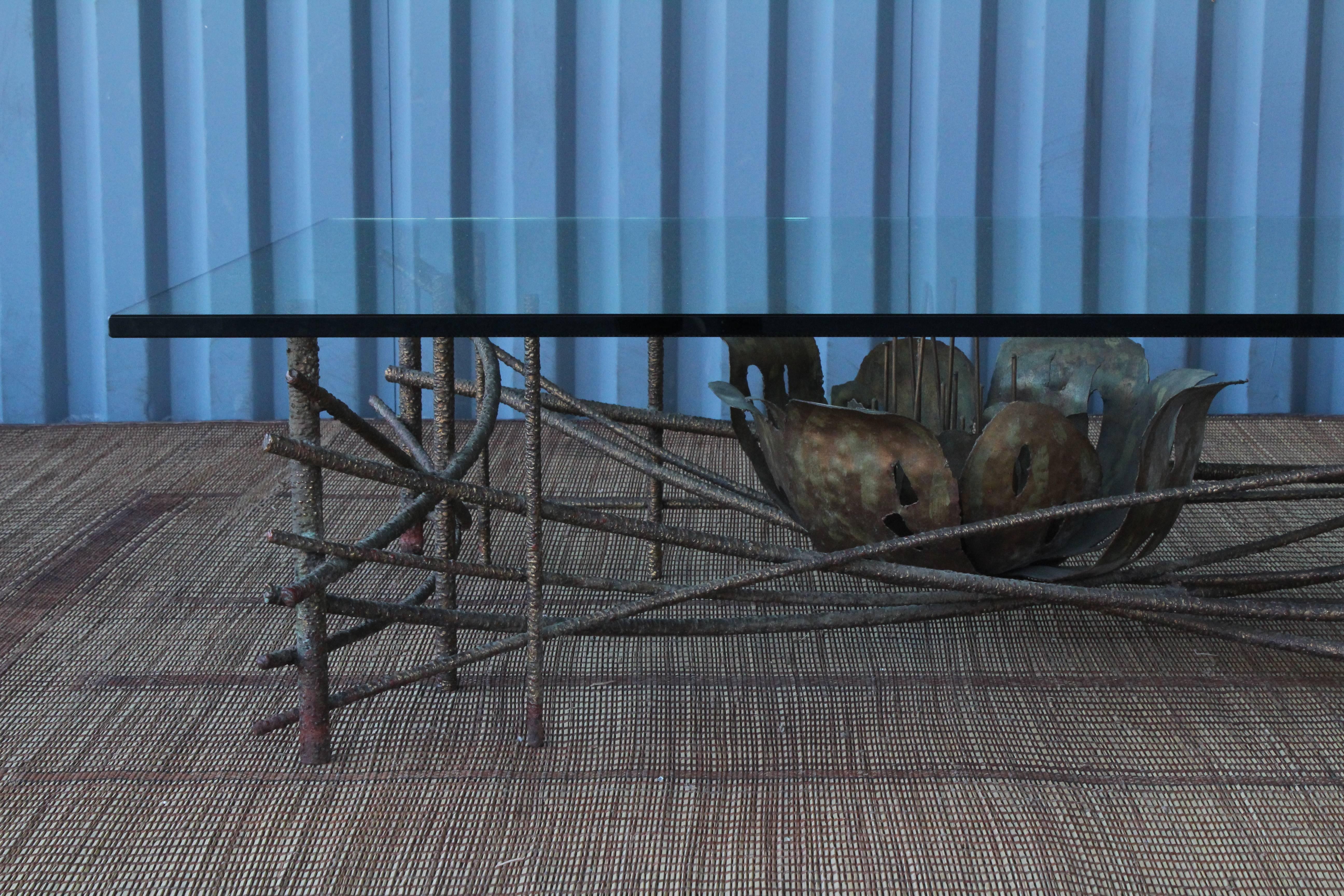 A beautiful Brutalist style coffee table by Silas Seandal made in the 1960s. Features a torch cut bronze water lily in the center. Includes a new custom fit glass top.