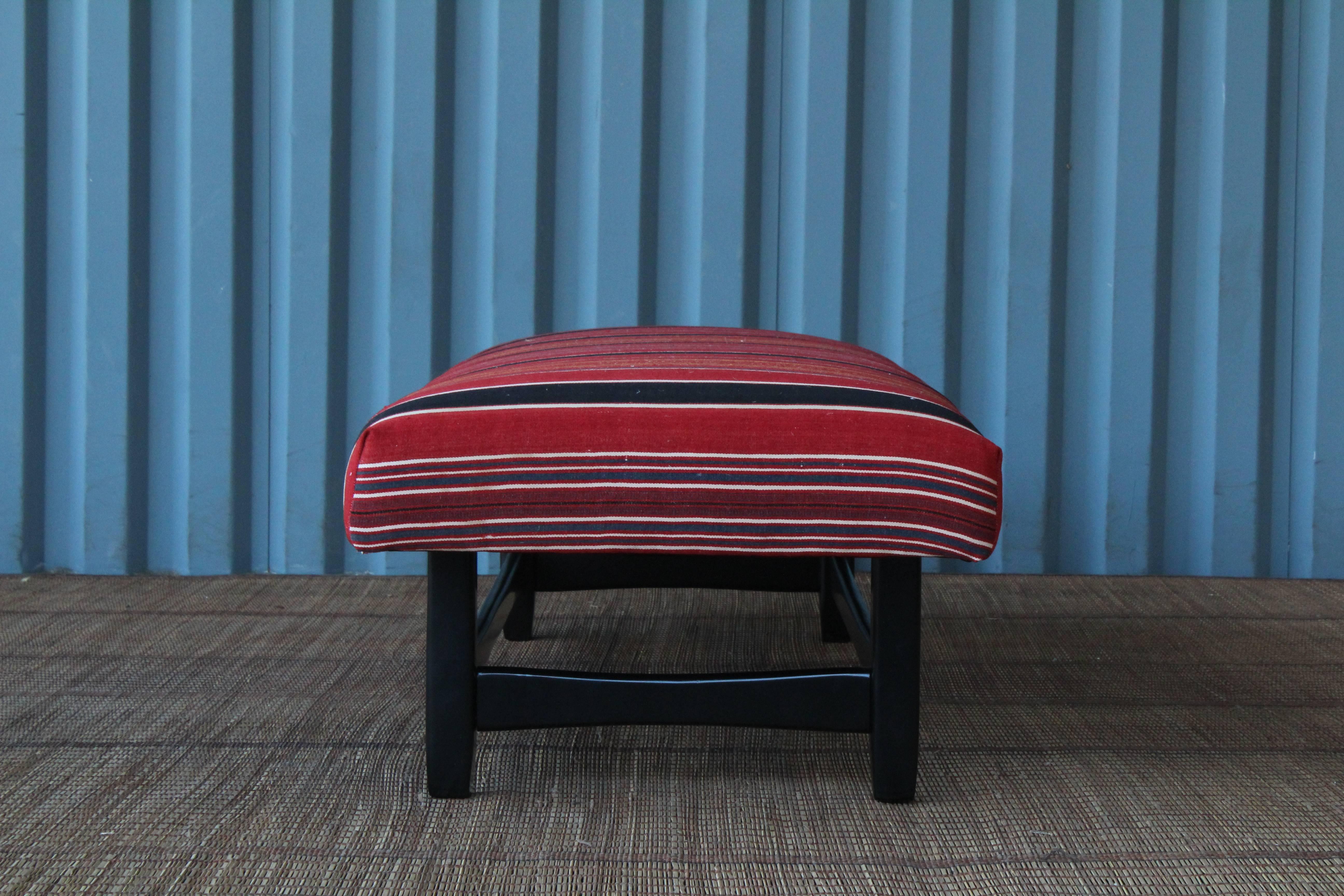 Upholstered bench with a midcentury style black lacquered base, newly upholstered in a vintage wool striped textile.