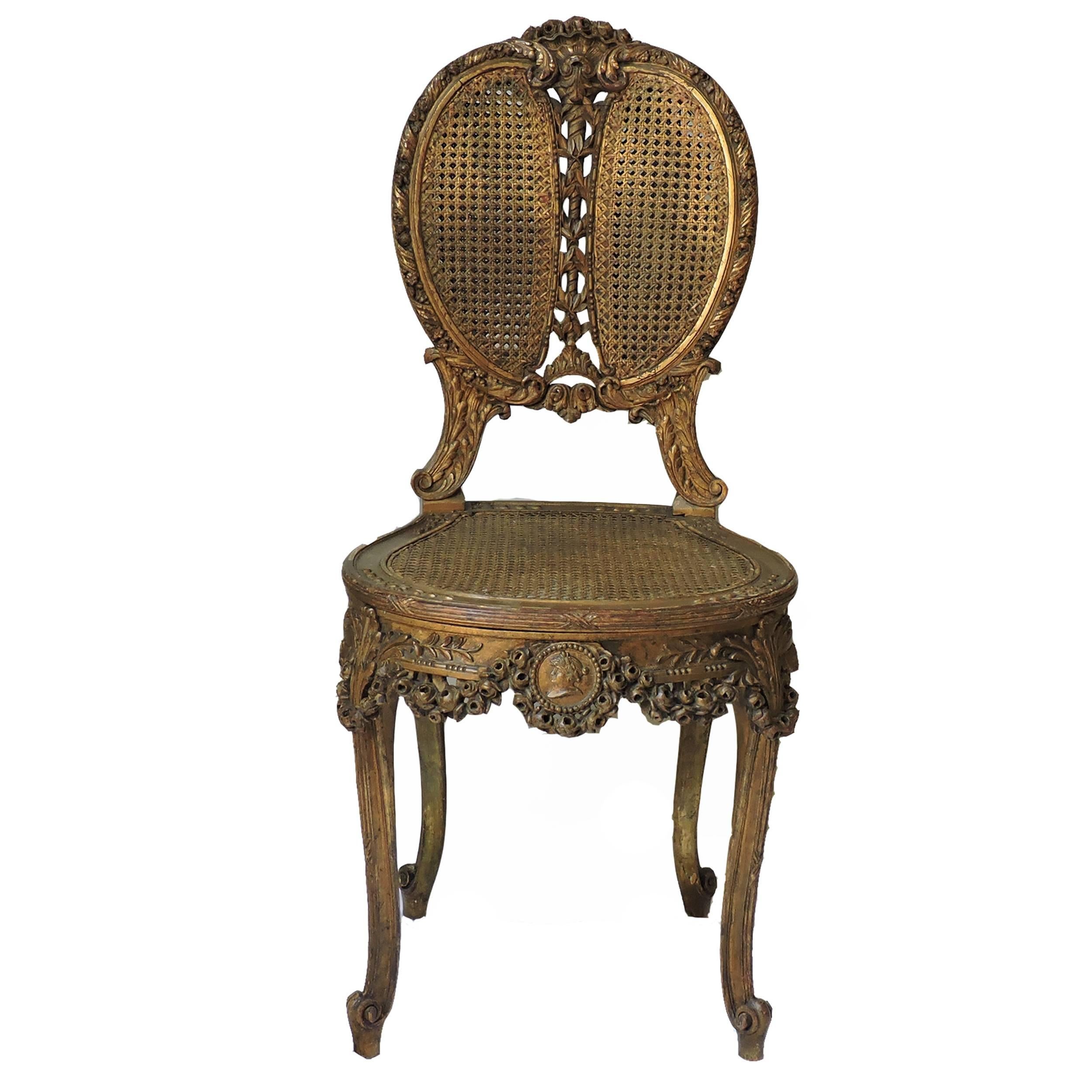 Finely carved Louis XIV giltwood chair with caned back and seat. Chair apron and legs are decorated with a floral motif. Caning is in excellent condition.