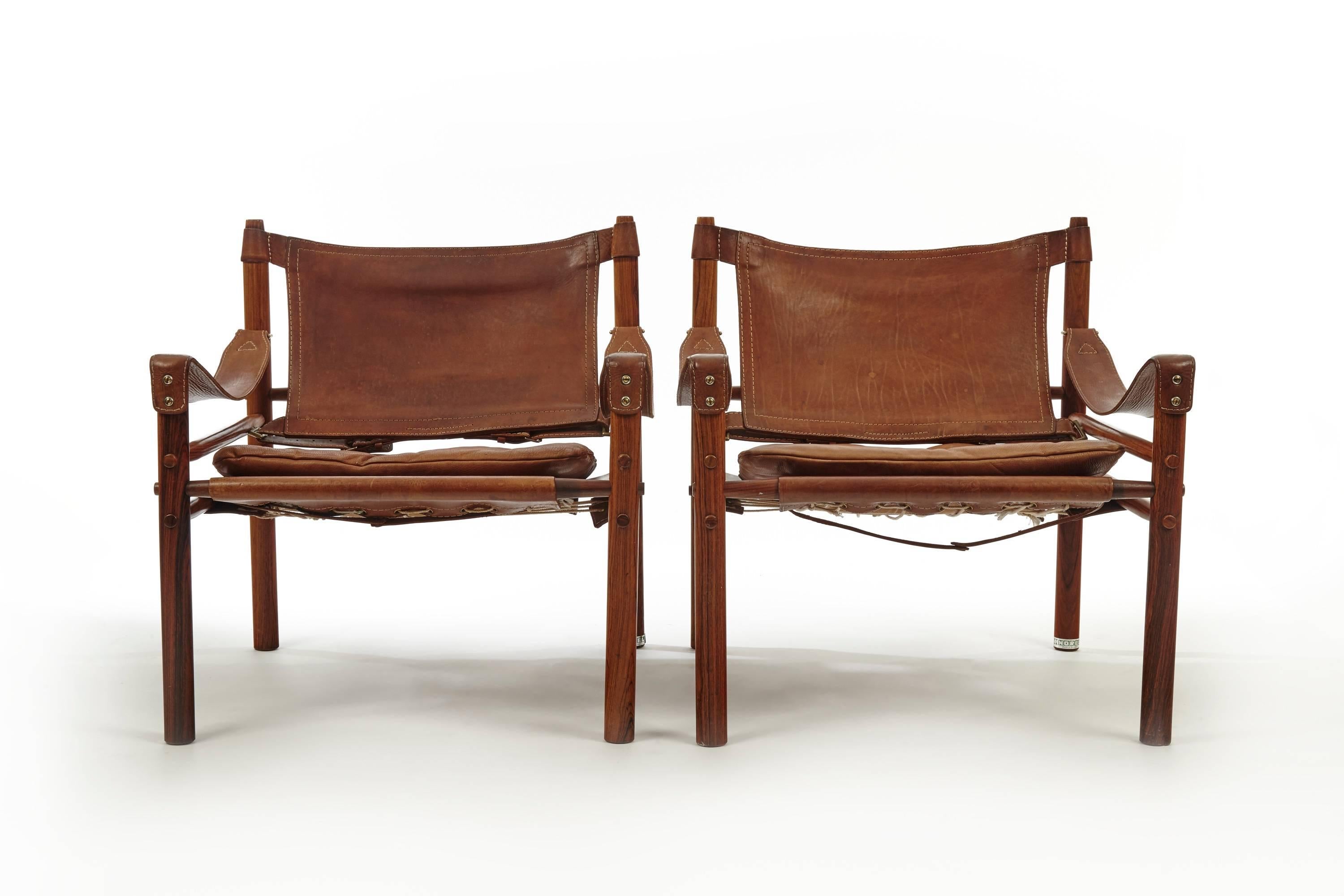 A beautiful pair of rosewood Arne Norell Safari chairs. Perfect leather patina and stunning rosewood grain. Made by Aneby Mobler in Sweden with makers label intact. Some signs of wear and use, relative to age and use. Fast and inexpensive shipping