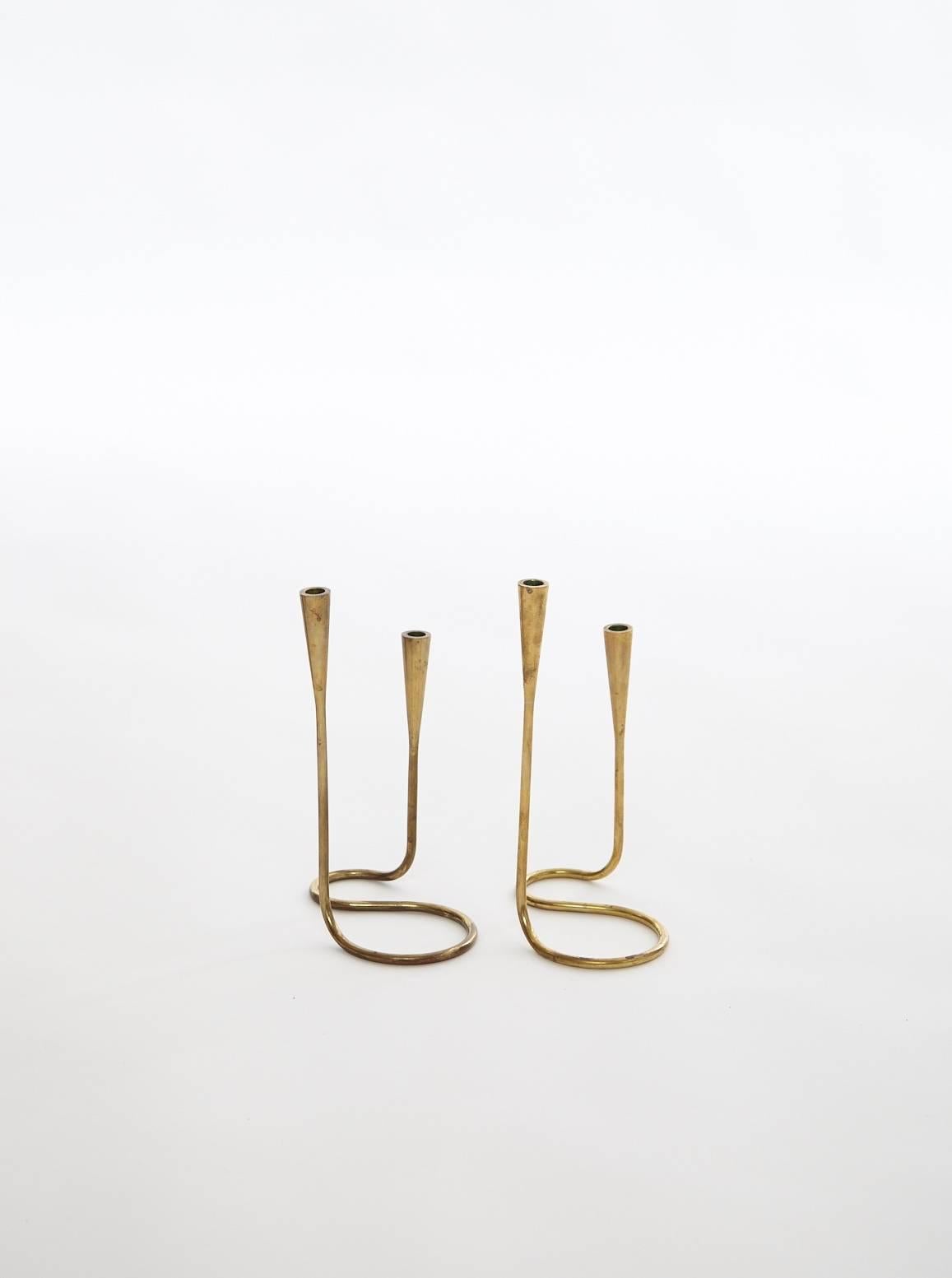 A rare pair of brass double ended Serpentine candlesticks by Illums Bolighus, Denmark, circa 1950s.