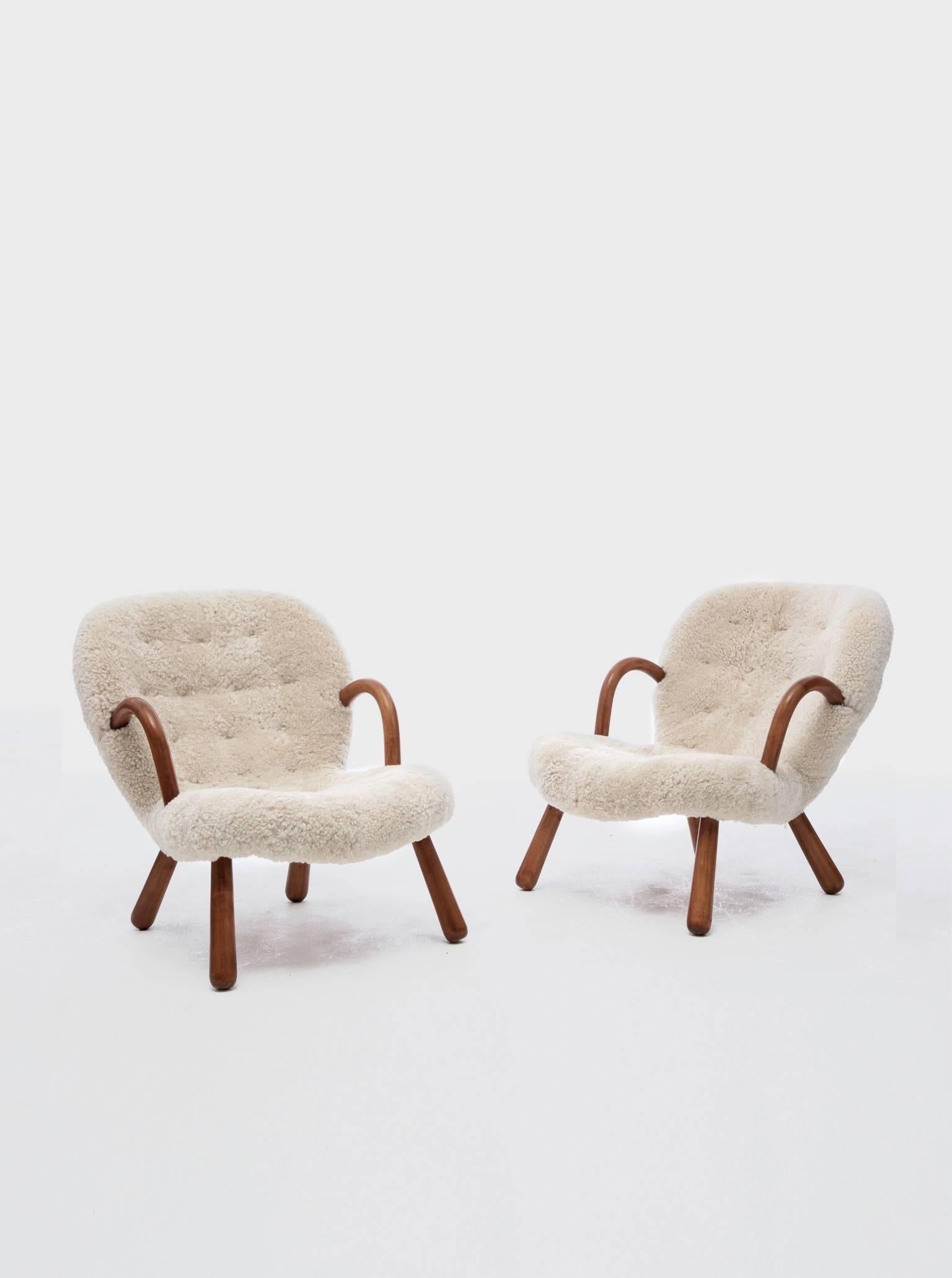 An authentic pair of clam armchairs designed by Philip Arctander with arms and legs of stained beech and reupholstered in sheepskin. Designed in 1944. Ships worldwide. **complimentary US shipping during January**
       
    