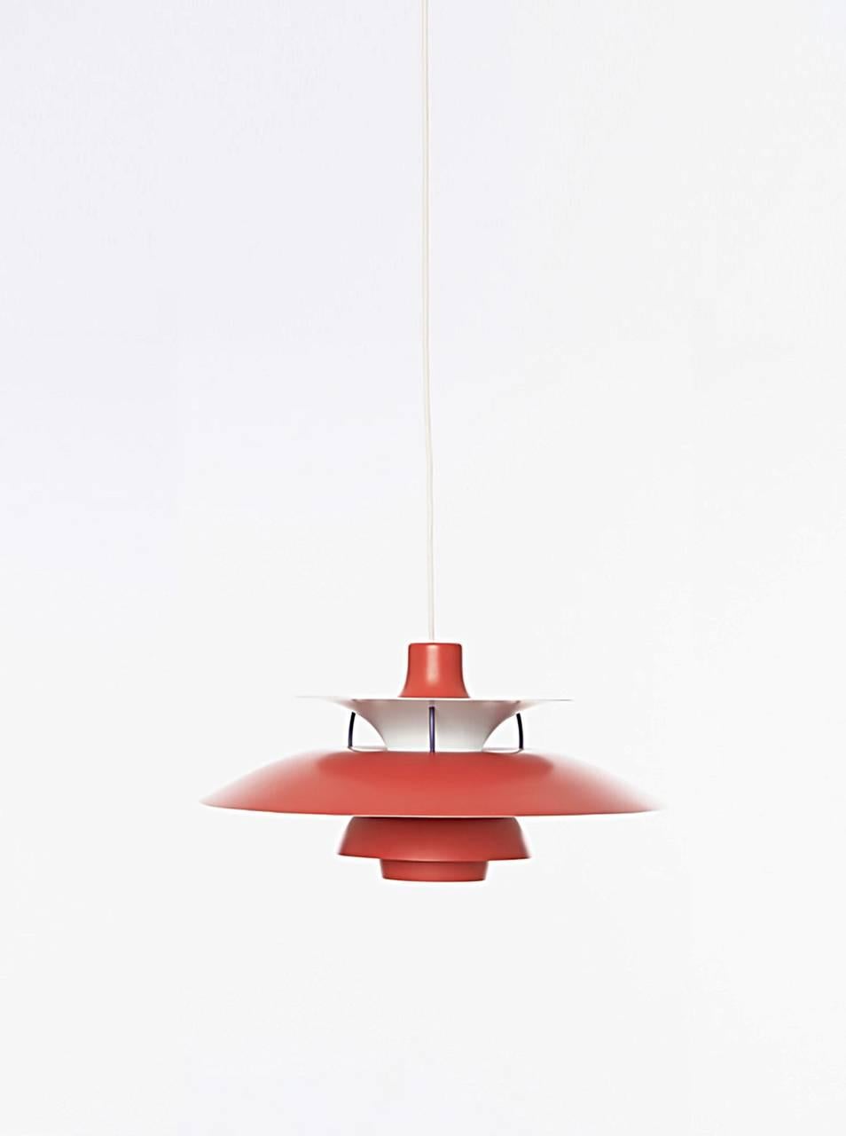 A vintage PH5 hanging lamp designed by Poul Henningsen for Louis Poulsen. First manufactured in 1957 for Louis Poulsen, this striking vintage PH5 pendant is one of the most recognizable designs by Poul Henningsen. Original red color finish with blue