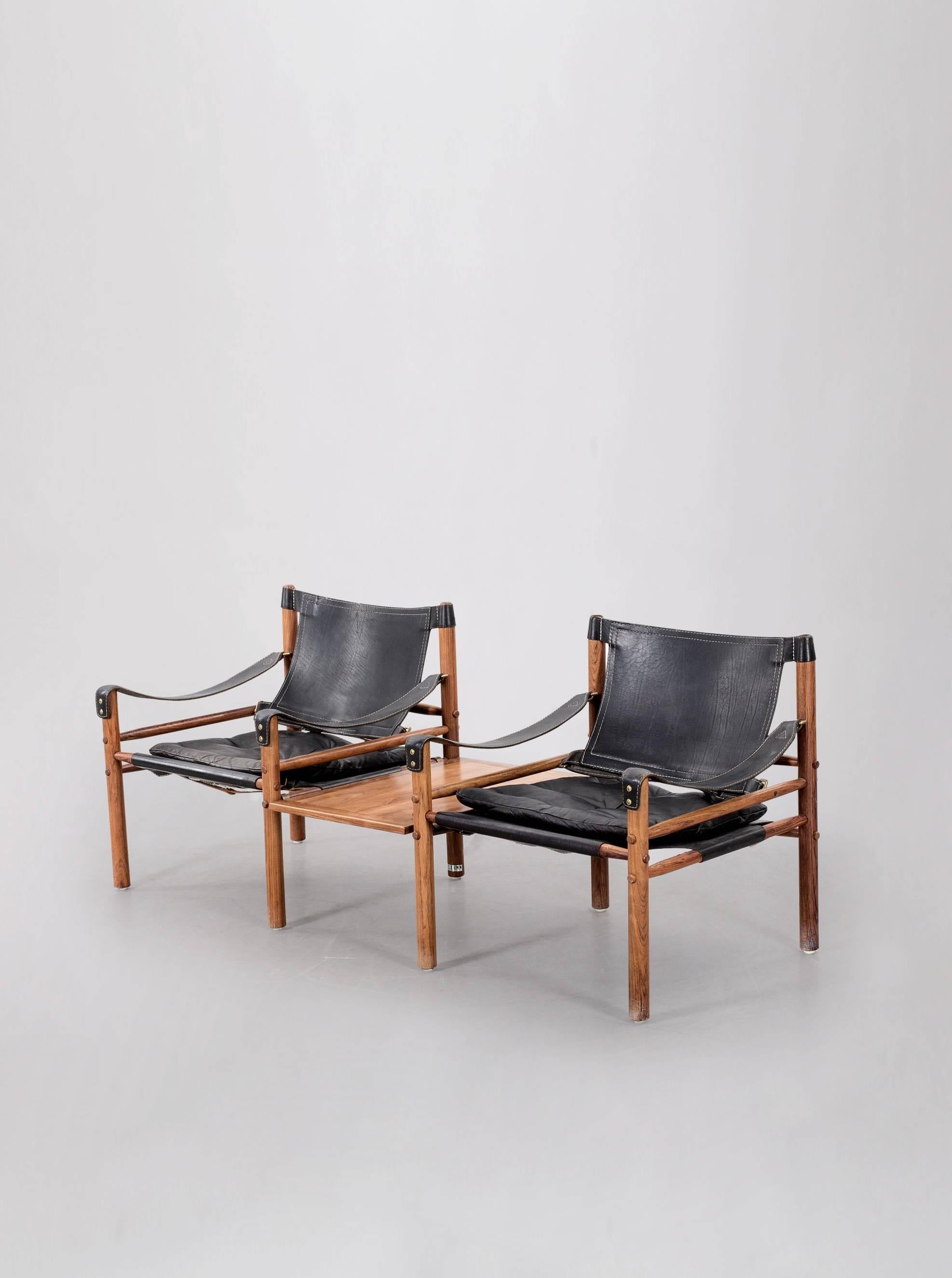 A super original pair of Arne Norell safari sirocco chair in rosewood and black leather with rare detachable table, 1960s, Sweden. In very good vintage condition. Made by Norell Möbel, AB, with makers label intact. Some minor signs of wear, relative