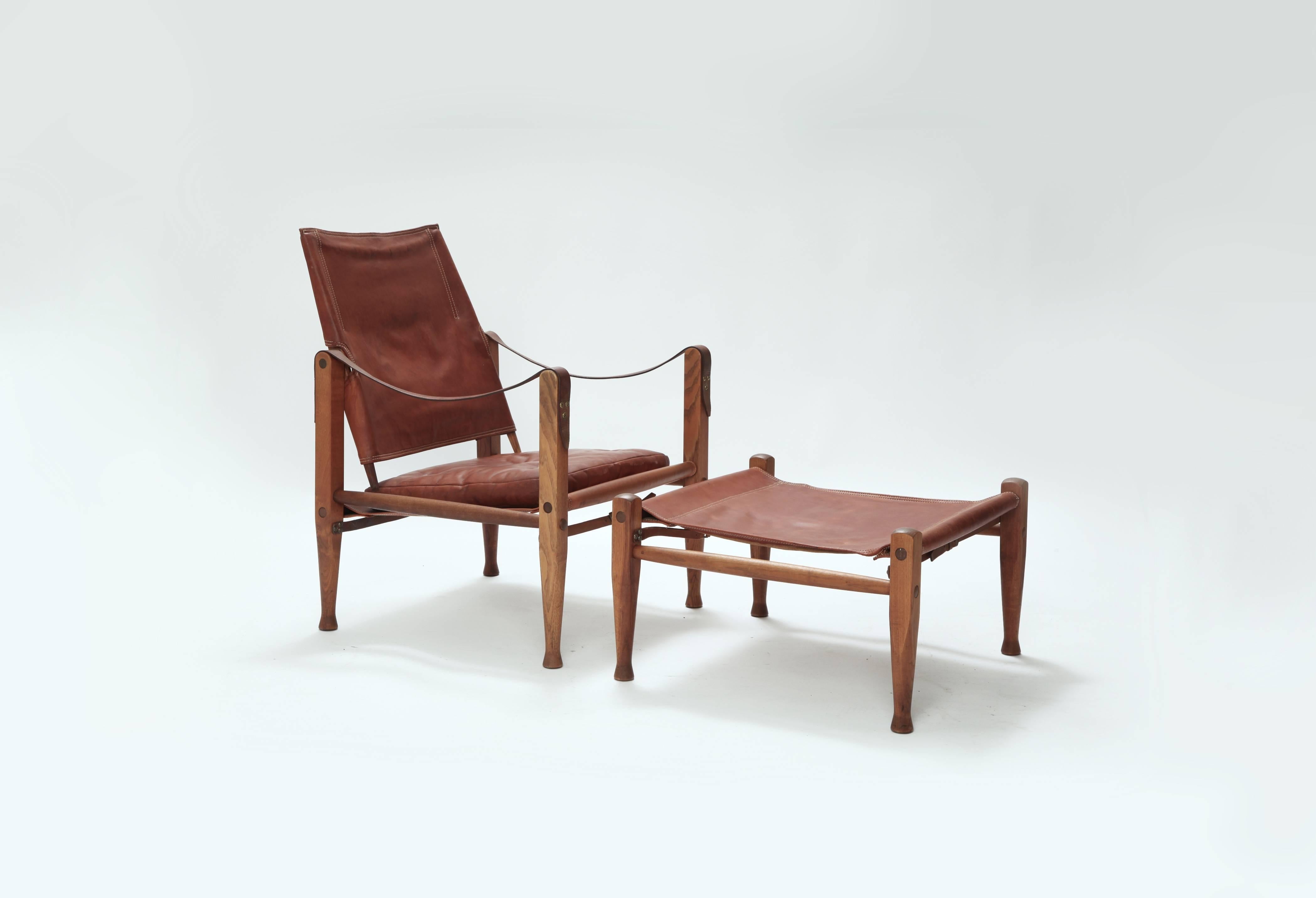 A rare safari chair and matching foot stool designed by Kaare Klint. Ashwood frame and beautifully patinated original leather seat and back. Designed in the 1933 by Kaare Klint for Rud. Rasmussen. Good condition.   
* complimentary US shipping