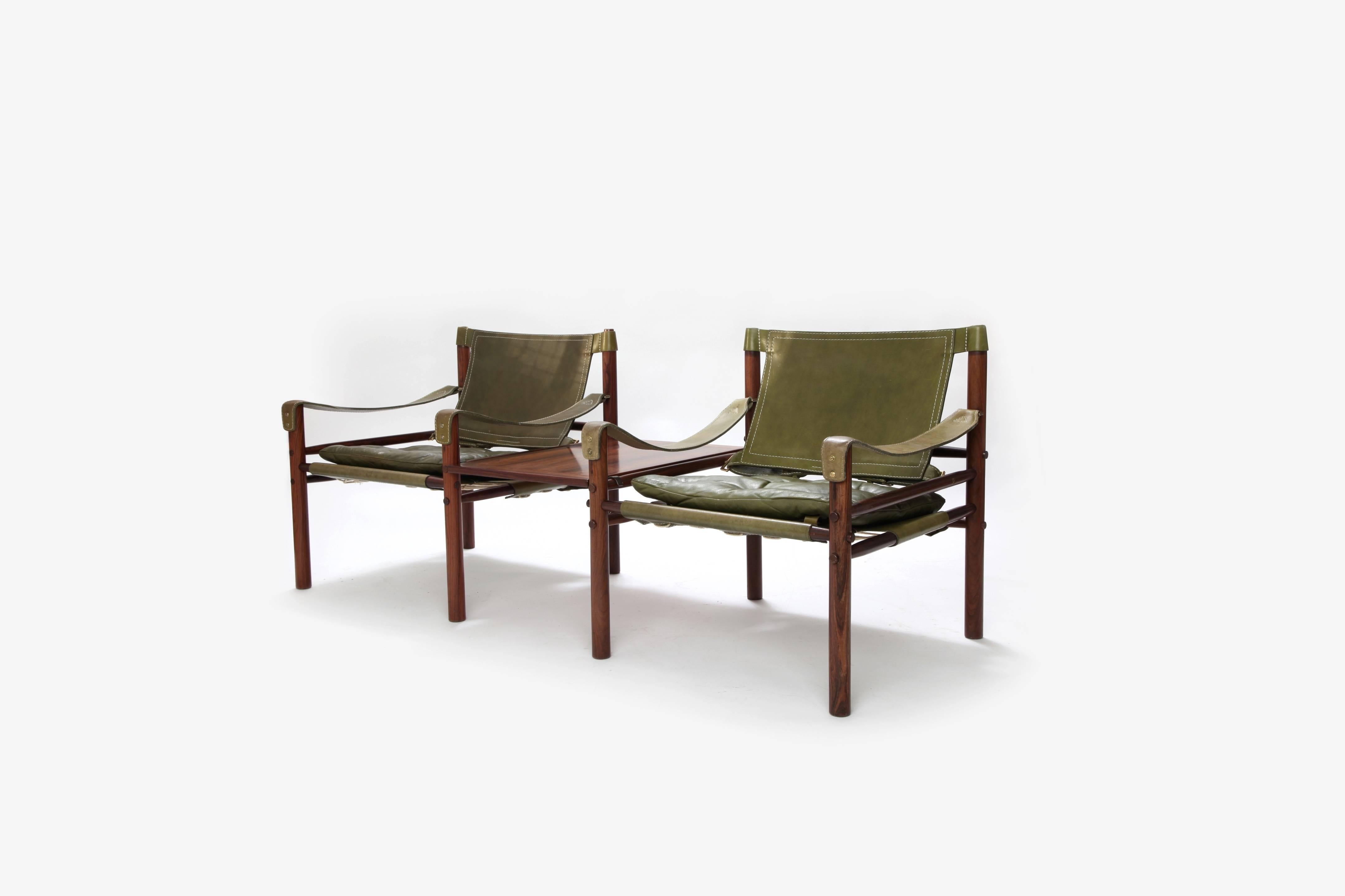 * complimentary US shipping during January *

A beautiful pair of rosewood Arne Norell Safari chairs with removable table. Made by Aneby Mobler in Sweden, 1960s. Fast and inexpensive shipping worldwide. The chairs will be disassembled for shipping