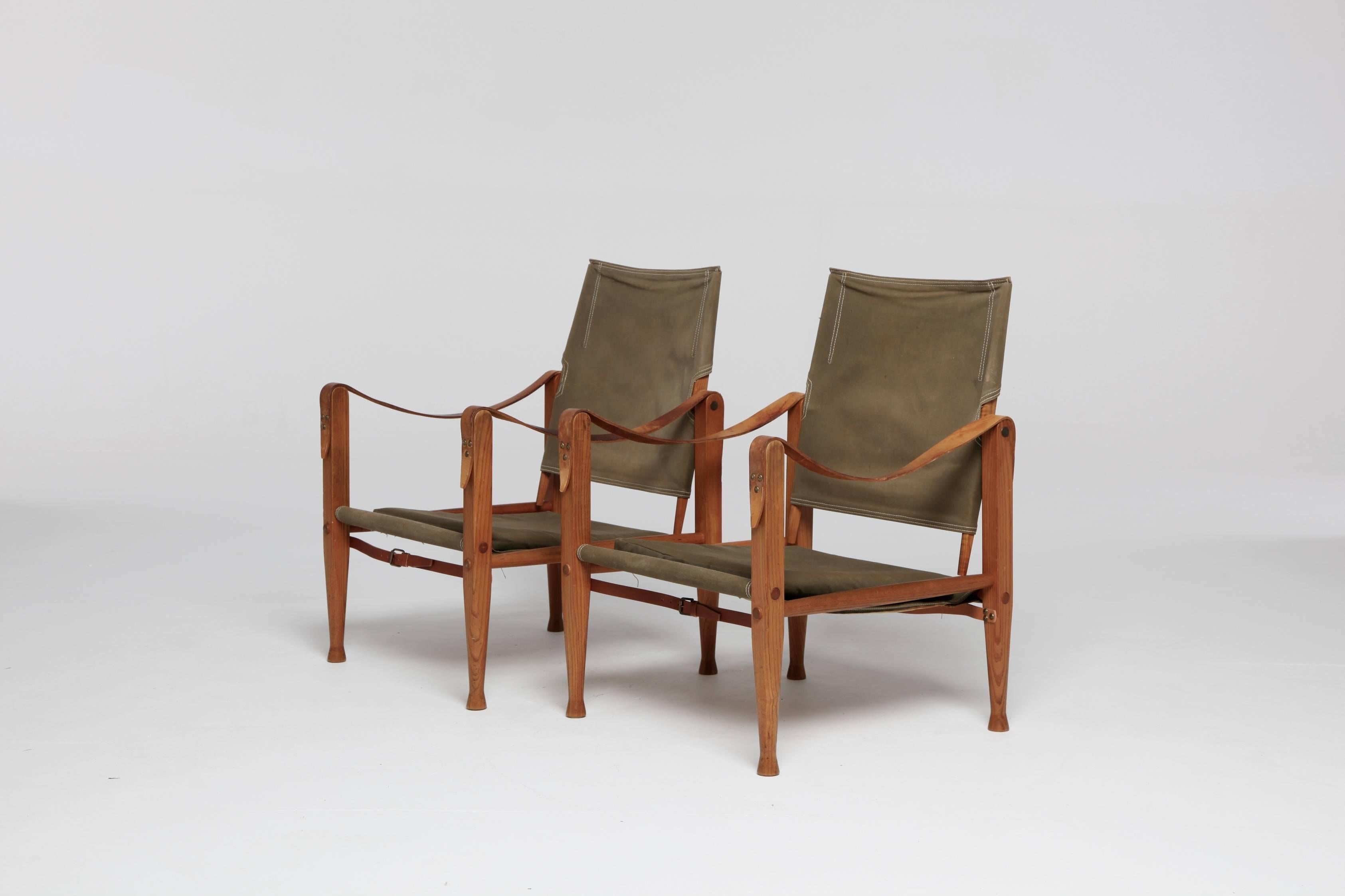 An authentic pair of vintage Kaare Klint safari chairs in original olive / khaki canvas. Designed in 1933 and produced by Rud Rasmussen, Denmark, with labels intact.

Fast worldwide shipping to your door. The chairs will need to be disassembled