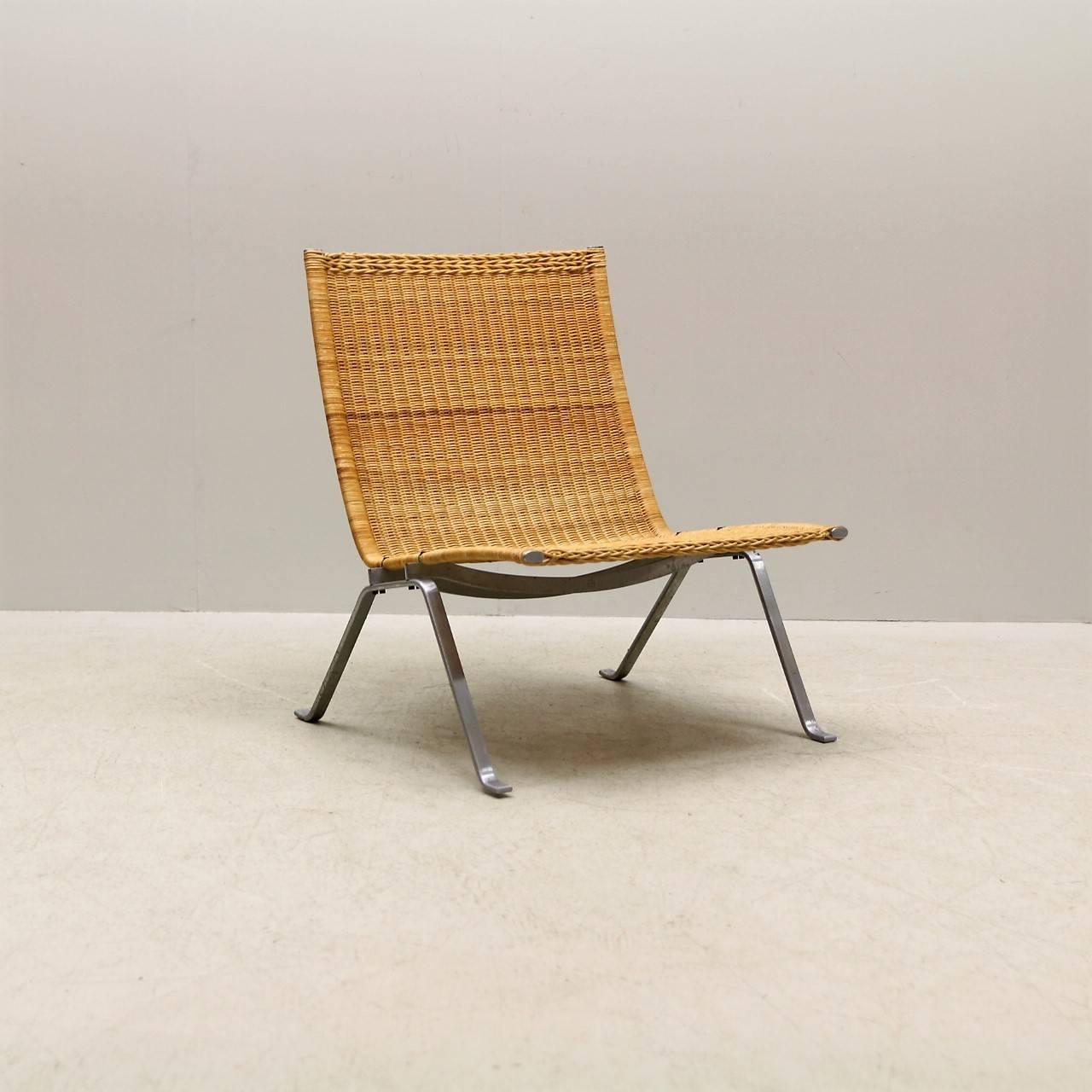 Poul Kjærholm PK-22 with a frame of steel, seat and back with original patinated cane. Designed by Poul Kjærholm in 1956 and manufactured and stamped by E. Kold Christensen, Denmark. Good vintage condition. Original cane intact. Minor wear and loss
