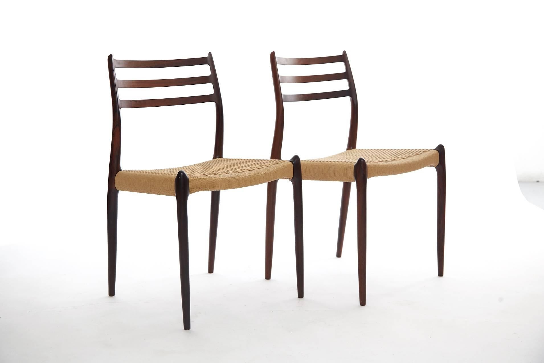 A set of four Niels O Moller model #78 rosewood dining chairs with papercord seats, Denmark, 1960s. Produced by J.L. Moller Mobelfabrik in Denmark and stamped with makers mark. Excellent condition.