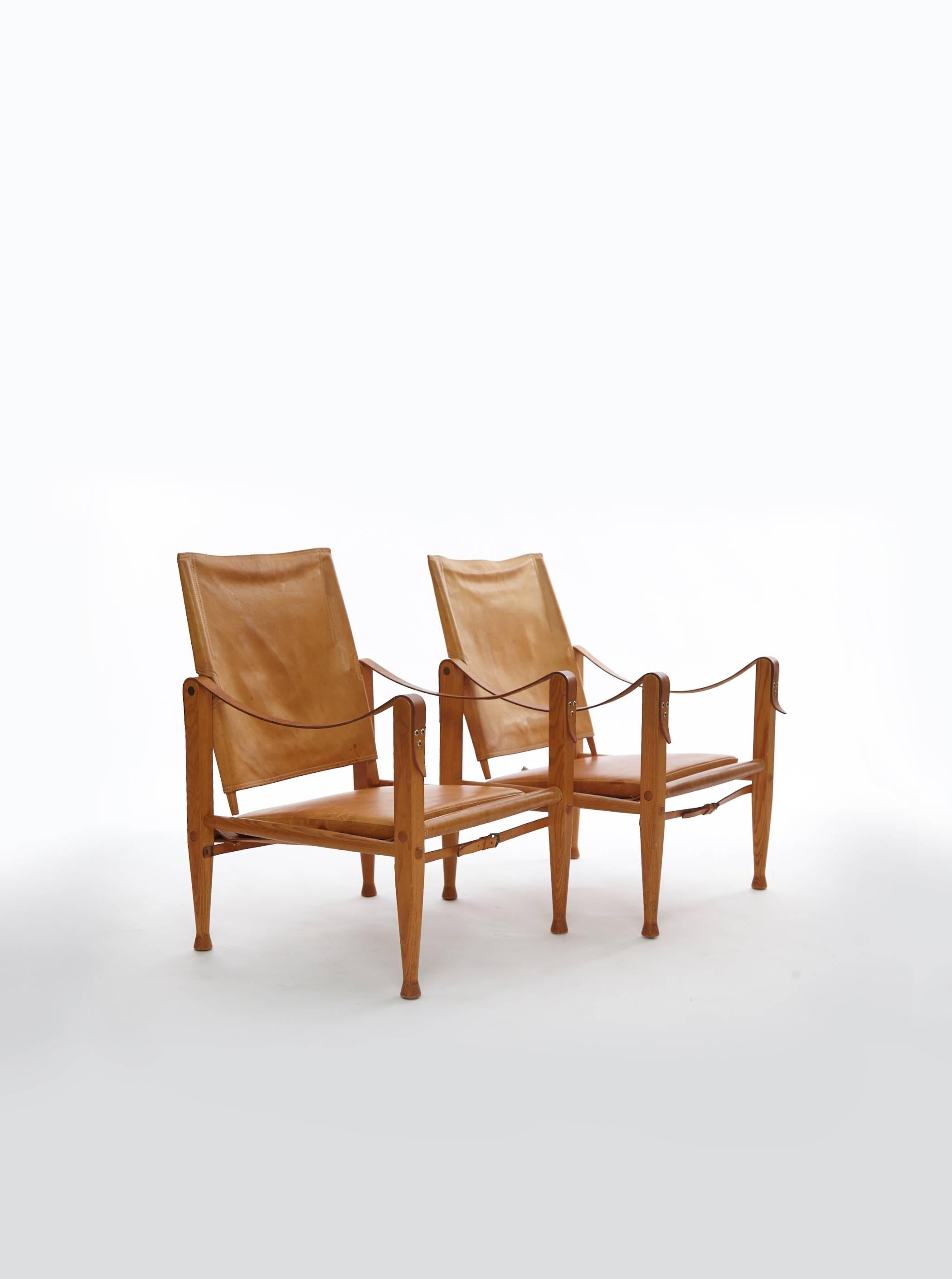 A pair of Kaare Klint safari chairs, made by Rud Rasmussen, Denmark. Tan/cognac leather and ashwood.