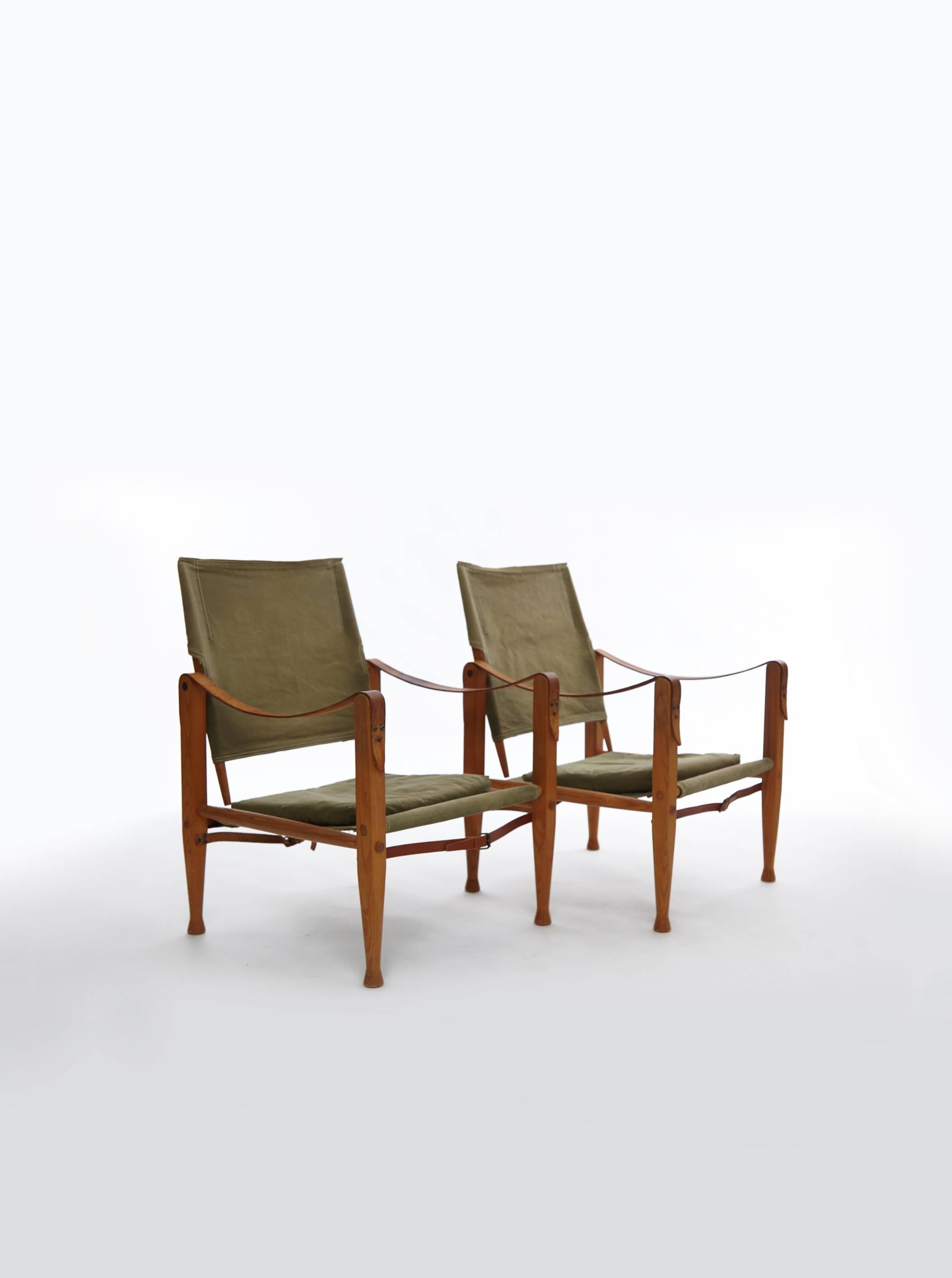 A pair of Kaare Klint Safari chairs, made by Rud Rasmussen, Denmark. Olive / khaki canvas and ashwood.   Ships worldwide.