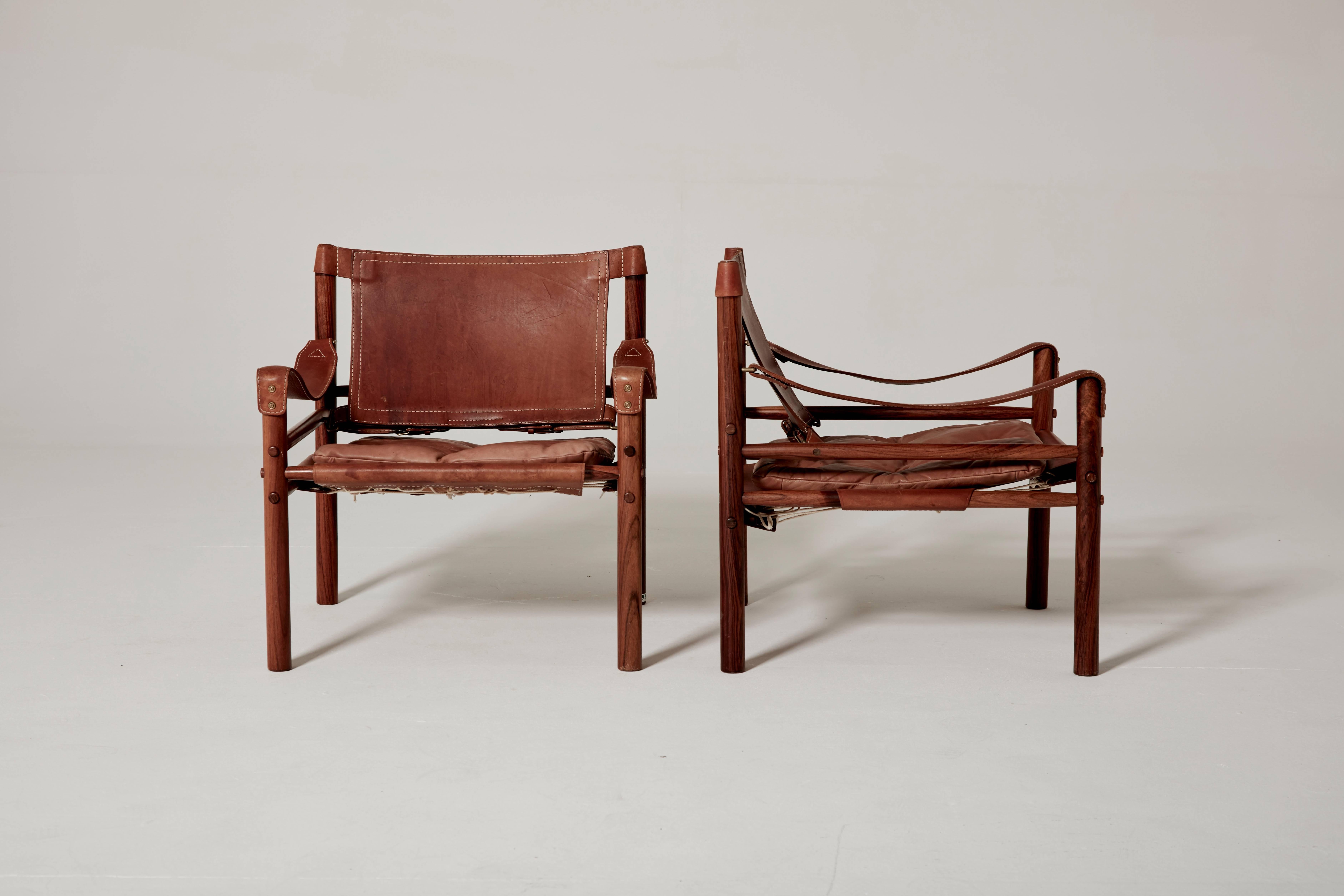 An exceptional original pair of Arne Norell safari sirocco chairs in rosewood and patinated brown leather, 1960s, Sweden. Made by Norell Möbel, AB, Sweden.