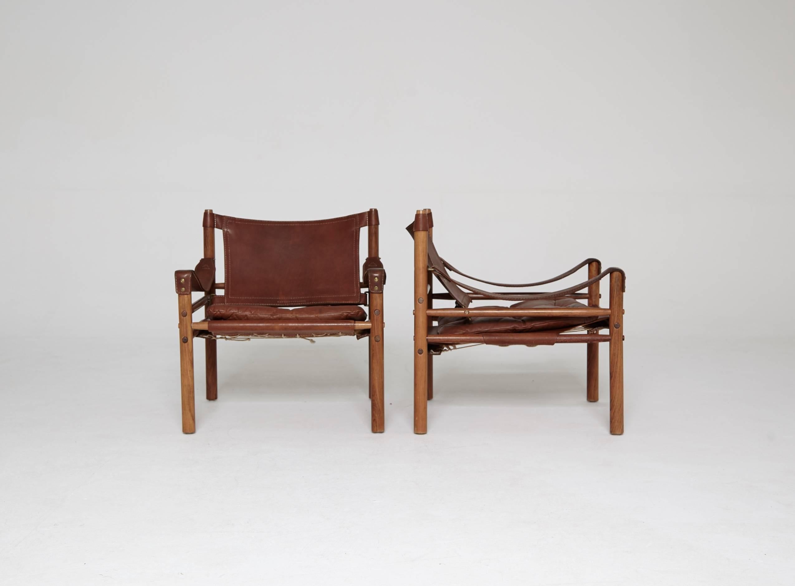 A stunning pair of authentic vintage Arne Norell safari sirocco chair in rosewood and brown leather. Made by Norell Mobler in Sweden. 

The chairs will need to be disassembled for shipping but were designed to be taken apart and put together again