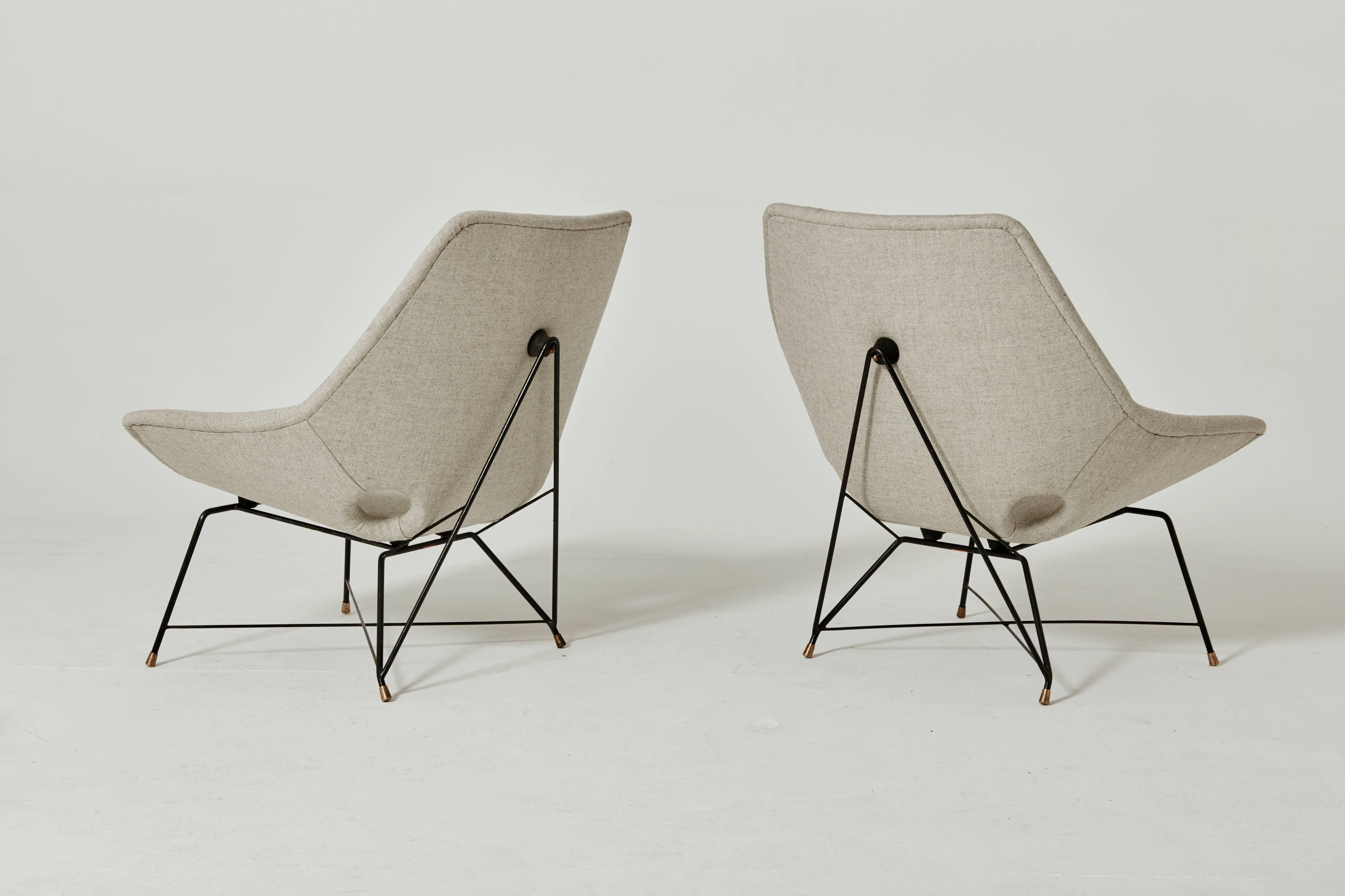 A wonderful and rare pair of lounge chairs designed by Augusto Bozzi for Saporiti Italia, Italy, 1954. The chairs have a black lacquered metal base with solid brass feet and are newly upholstered in Kvadrat wool fabric. Makers label to underside.