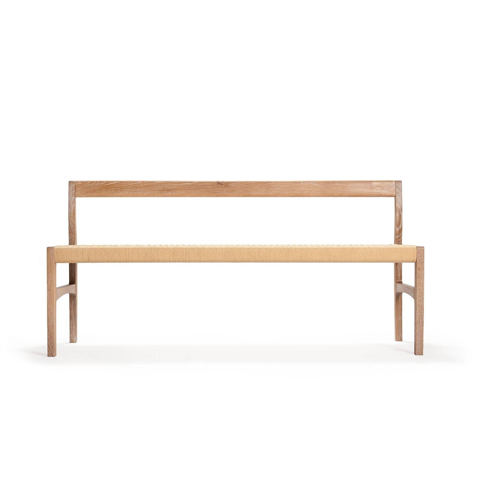 A bench with subtle curves in solid white oak, white-oiled, with woven paper cord seat, perfect for use in the bedroom, hallway, living space or kitchen.