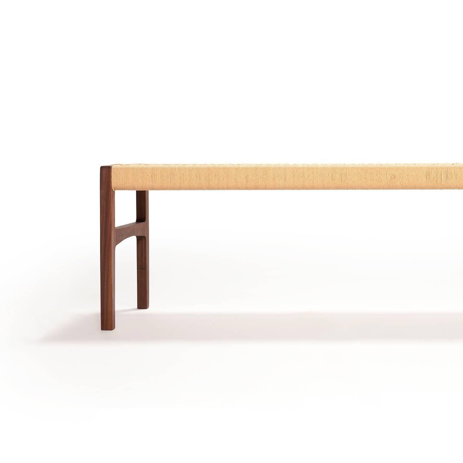 A bench with subtle curves in solid walnut with woven danish cord seat, perfect for use in the bedroom, hallway, living space or kitchen. Measure: 59