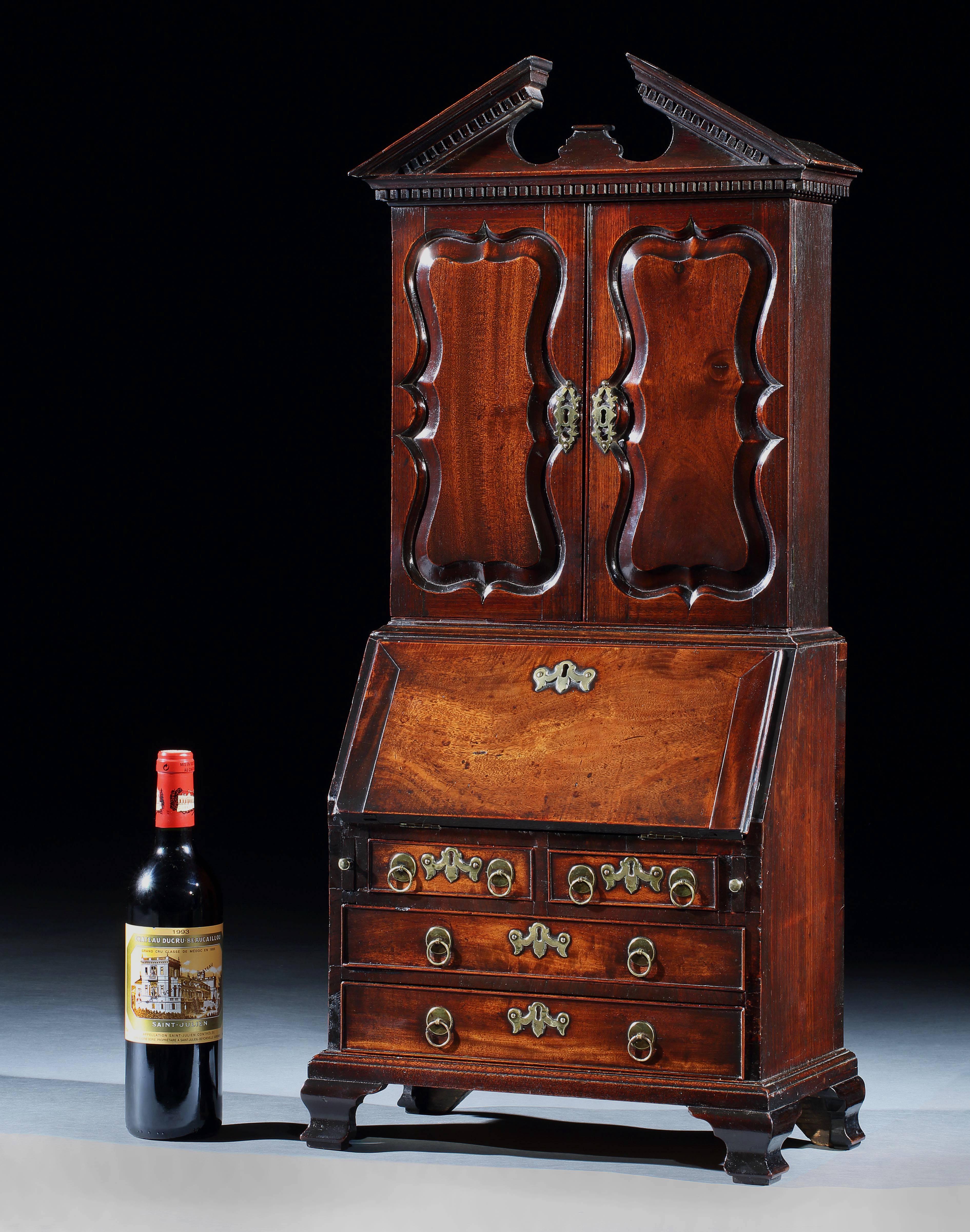 A rare and superb quality George III miniature mahogany bureau cabinet, retaining the origianl handles and ogee feet.
​
English, circa 1770.

 The miniature books of a later date, and depicting various Shakesphere plays including, Romeo &