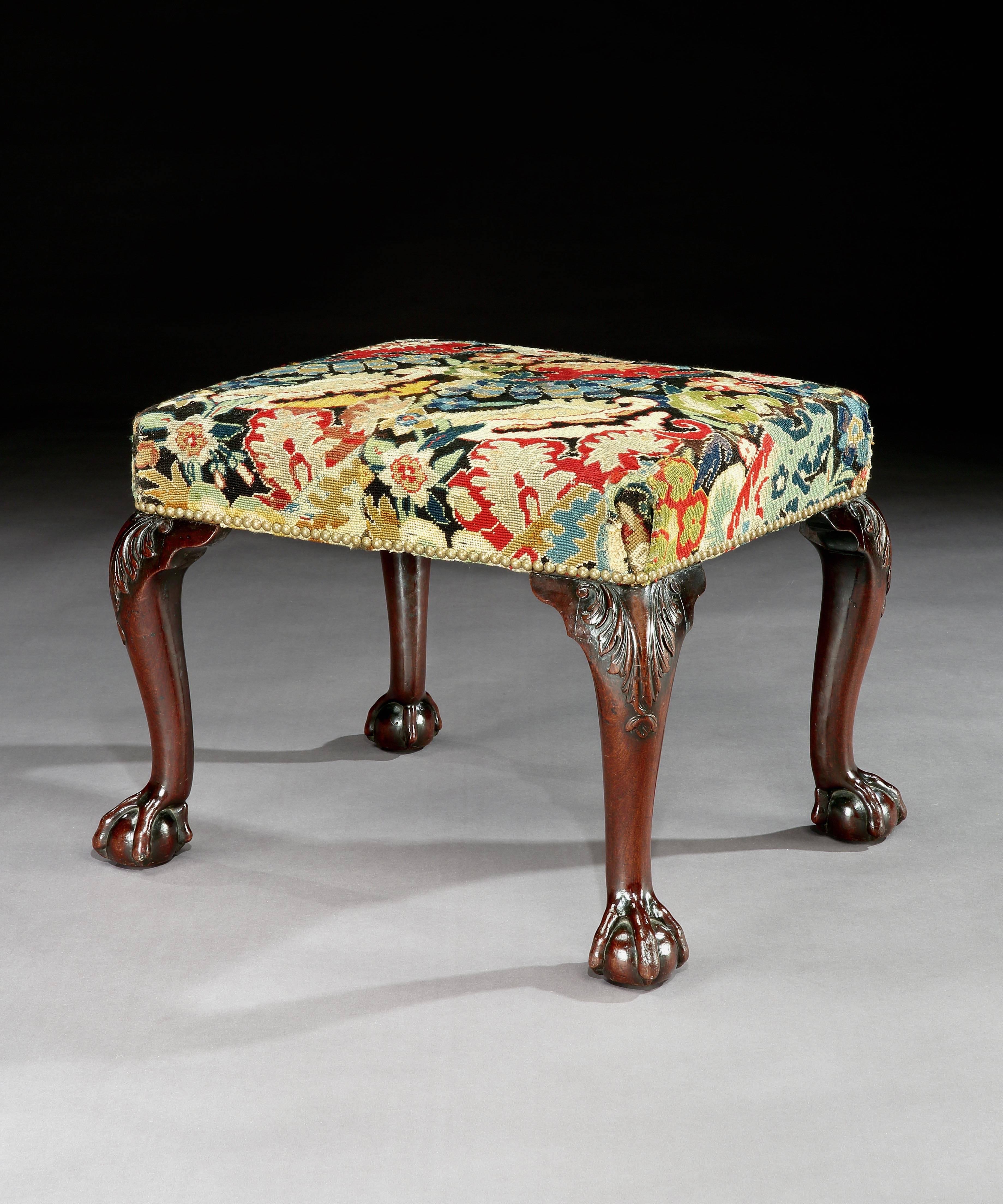 A George II mahogany stool covered in period needlework depicting a floral motif, the stool stands on four cabriole legs carved with acantus and terminating in ball and claw feet.
 
English, circa 1760.
​
Measures: Width: 21