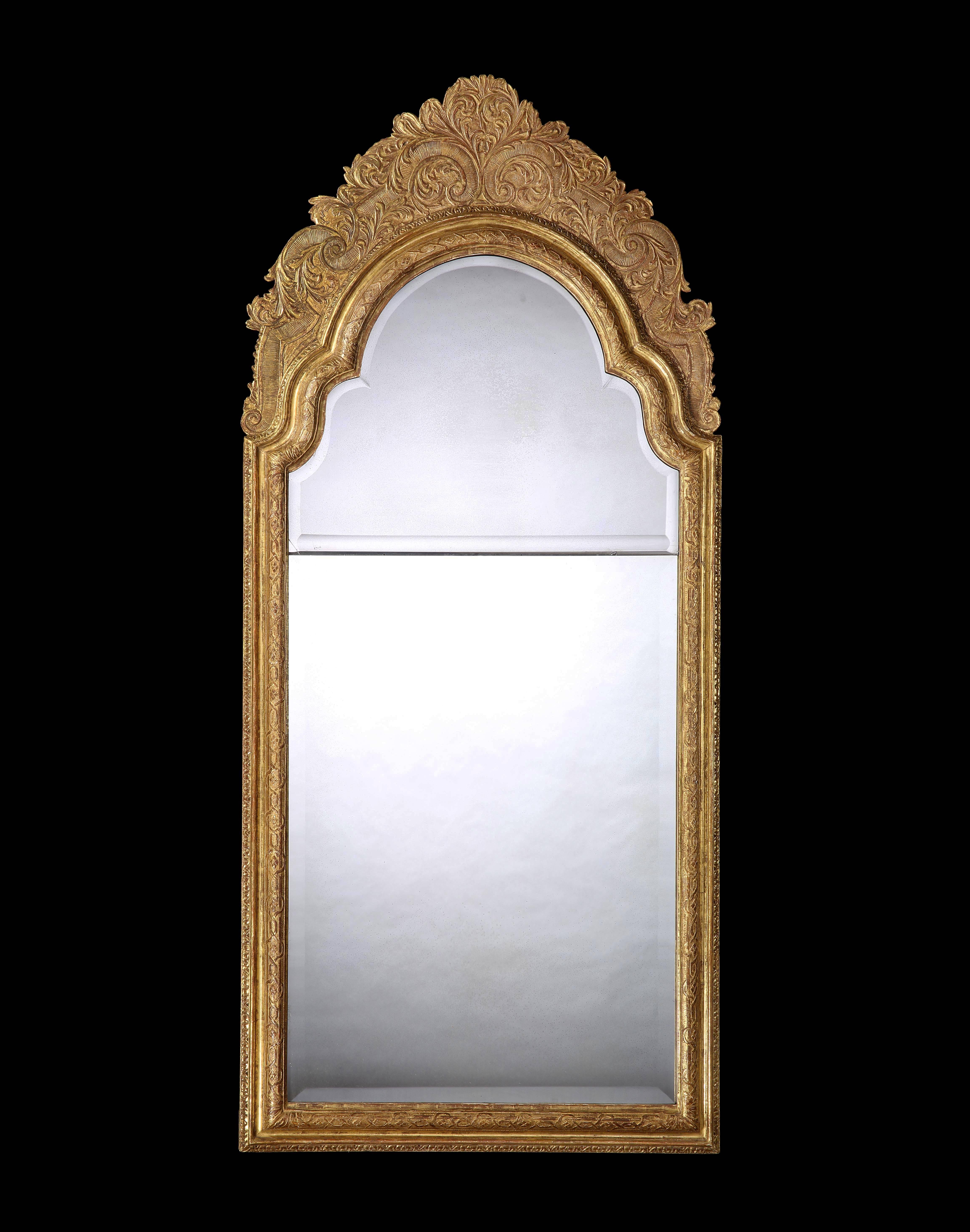 A rare large sized Queen Anne pier glass mirror, retaining the original re silvered bevelled top plate and with a later lower bevelled plate, the carved moulded frame depicting acanthus, floral garlands and a hatched pattern.
 
English, circa